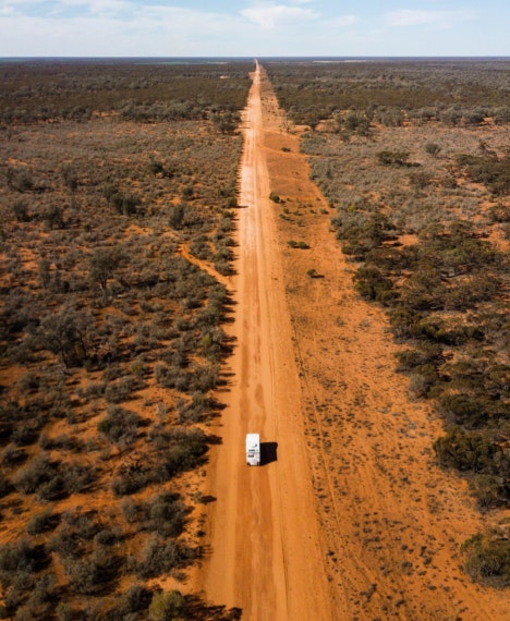 Drone image of Dental Truck driving on dirt road in Australian outback