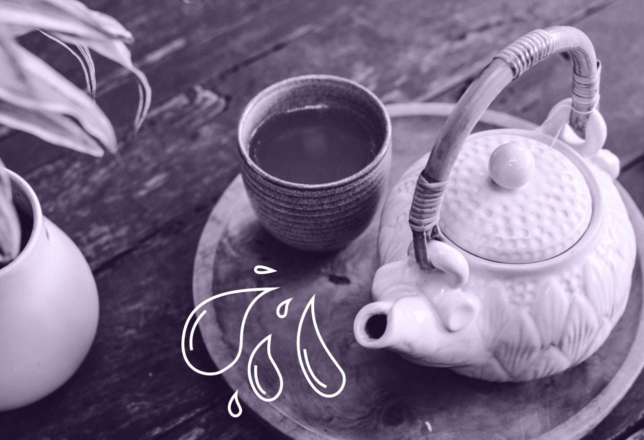 A tea cup and pot on a table