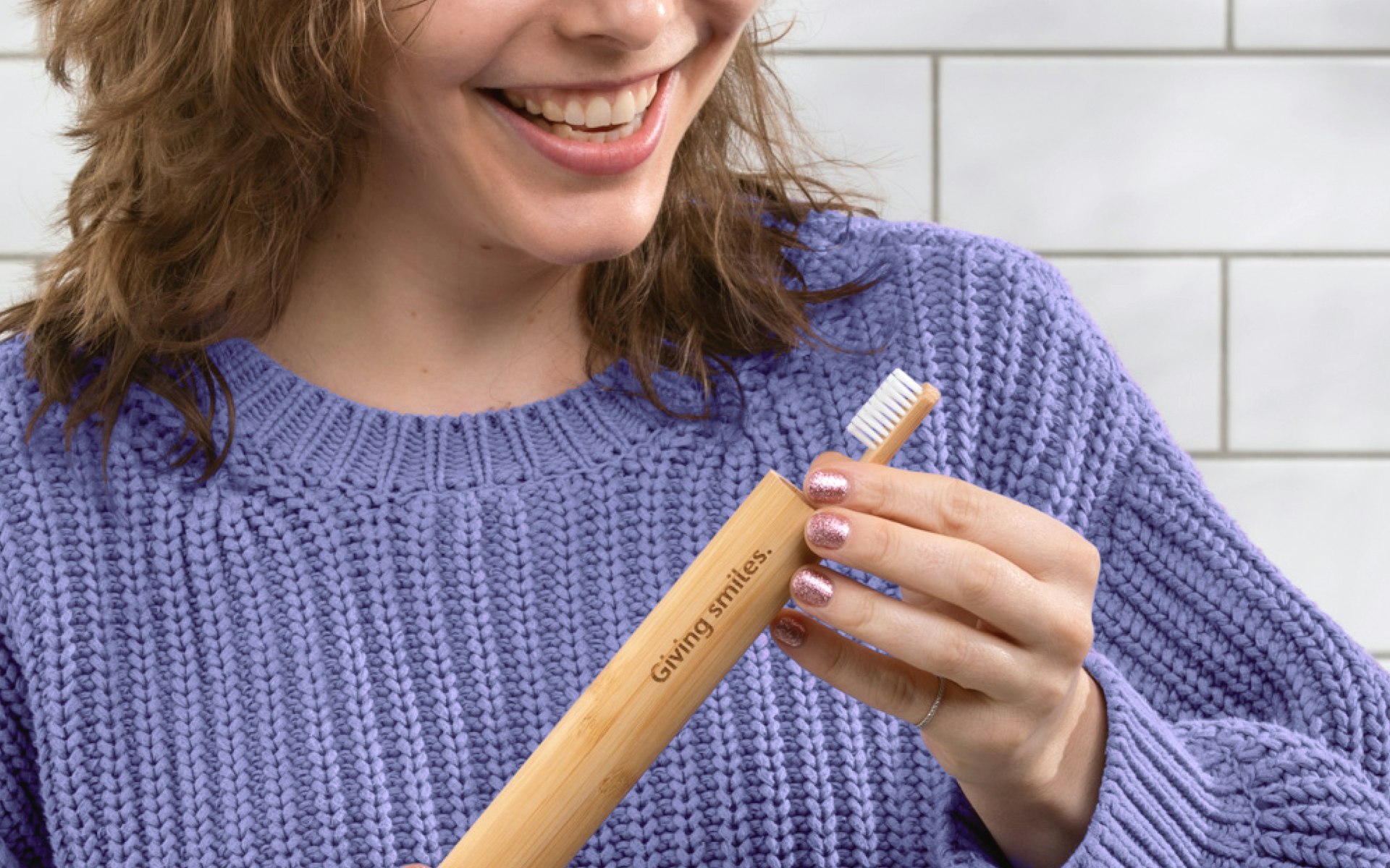 Woman in purple jumper placing her Pearlii Mosobrusgh into her Mosobrush Travel Case