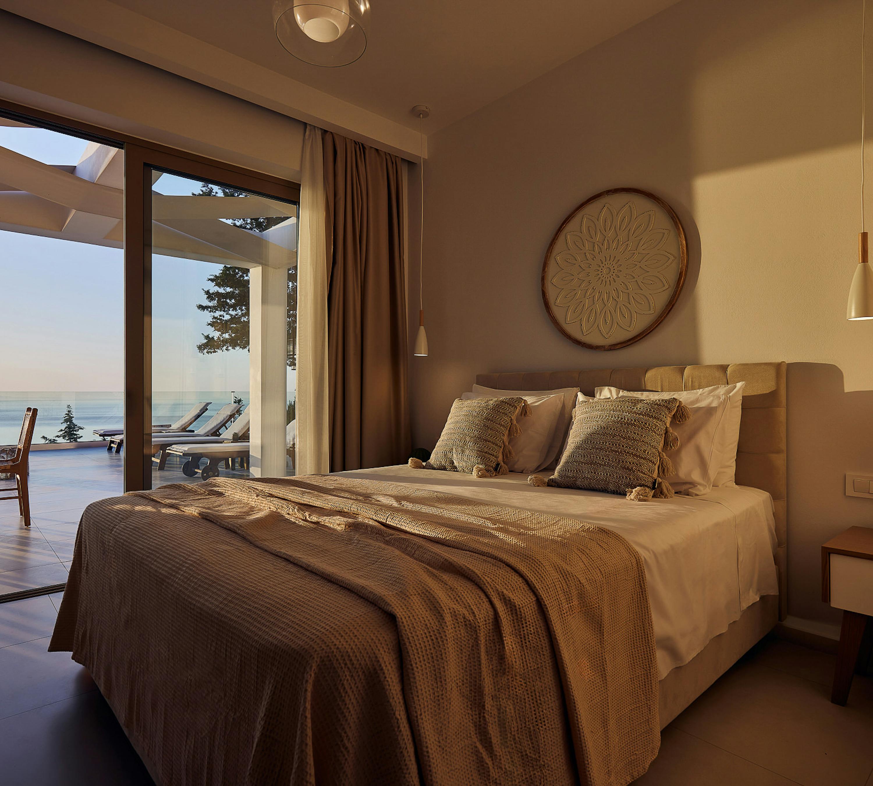 Tan sectional sofa with botanical pillows, paired wood coffee tables, and framed geometric art on wall.