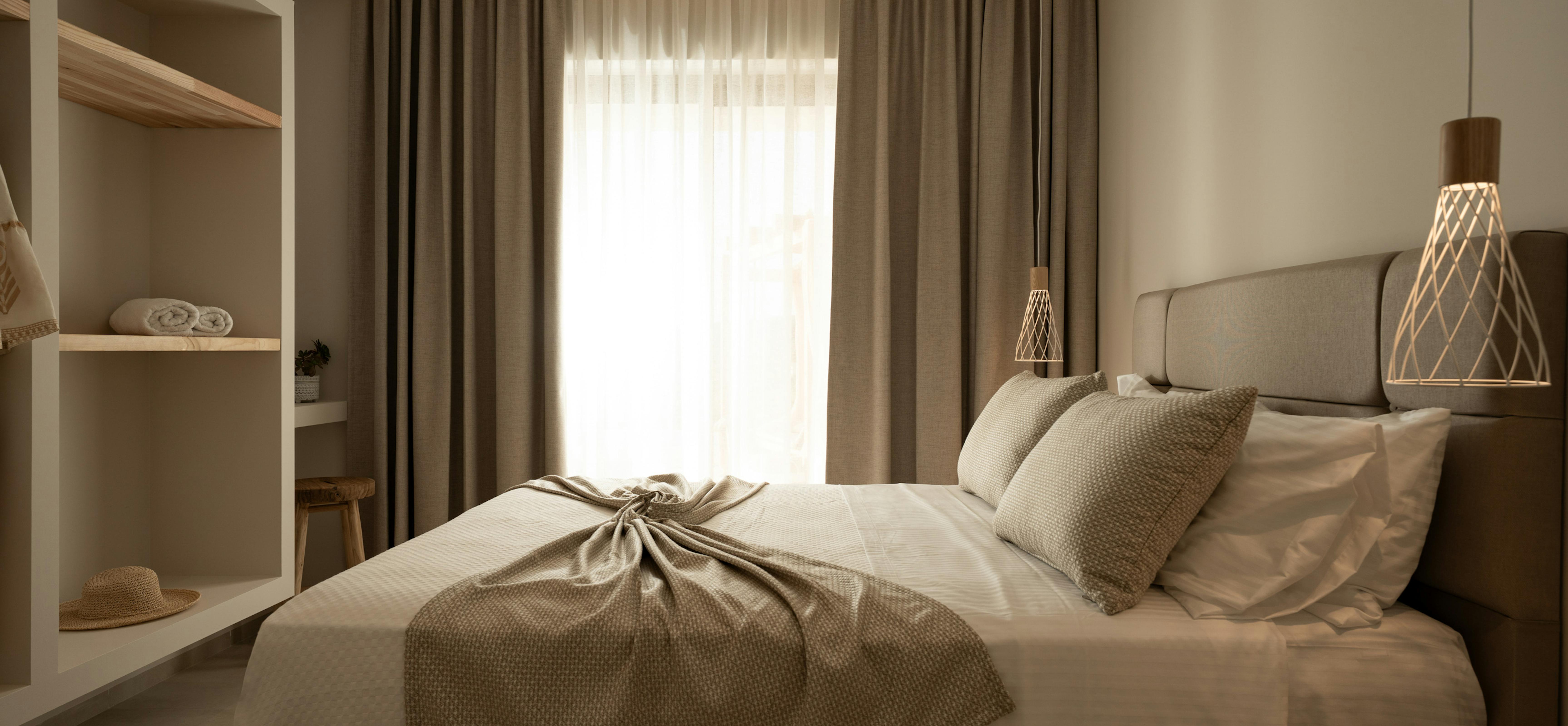 Modern bedroom with built-in white shelving, neutral bedding, and woven pendant lights flanking an upholstered headboard. Layered curtains filter natural light in this minimalist space.