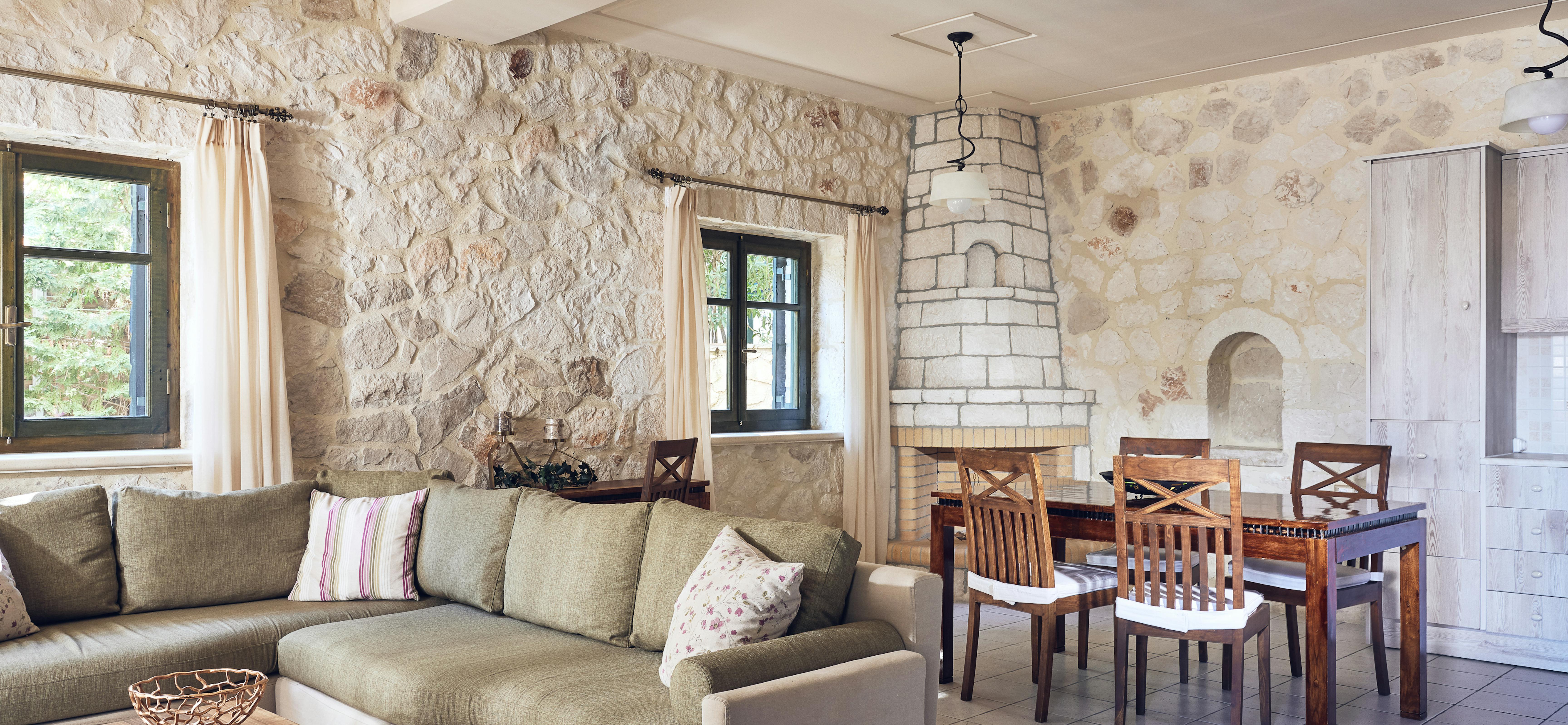 Open-plan living and dining area with traditional fireplace and natural stone construction.