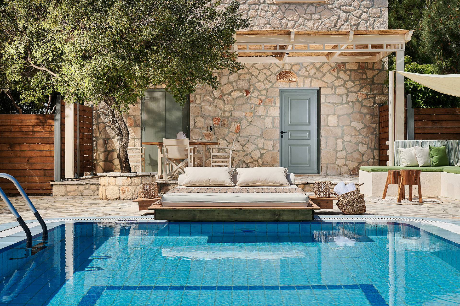 Pool area with built-in daybed platform and contemporary outdoor seating facing the Mediterranean.