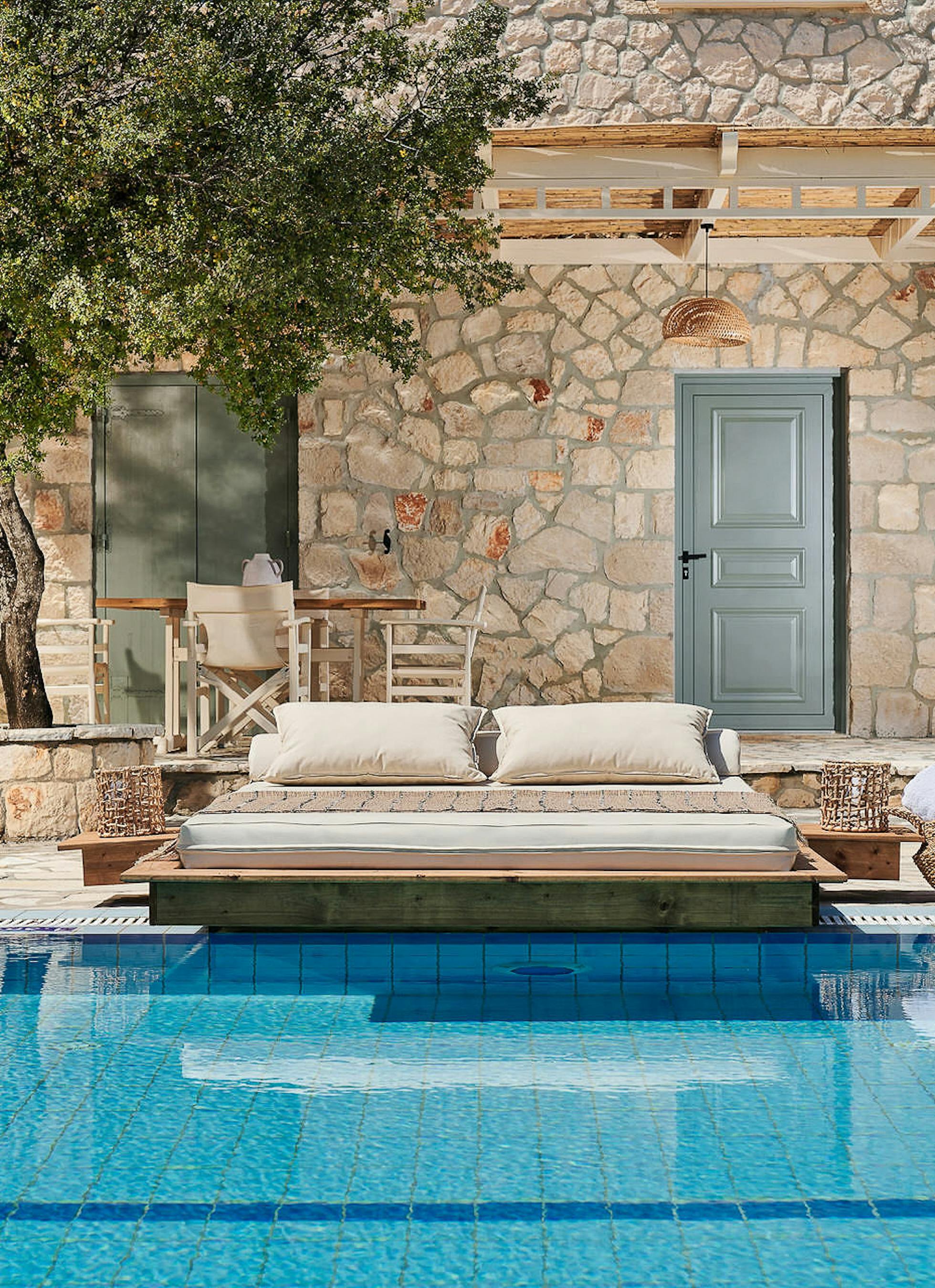 Pool area with built-in daybed platform and contemporary outdoor seating facing the Mediterranean.