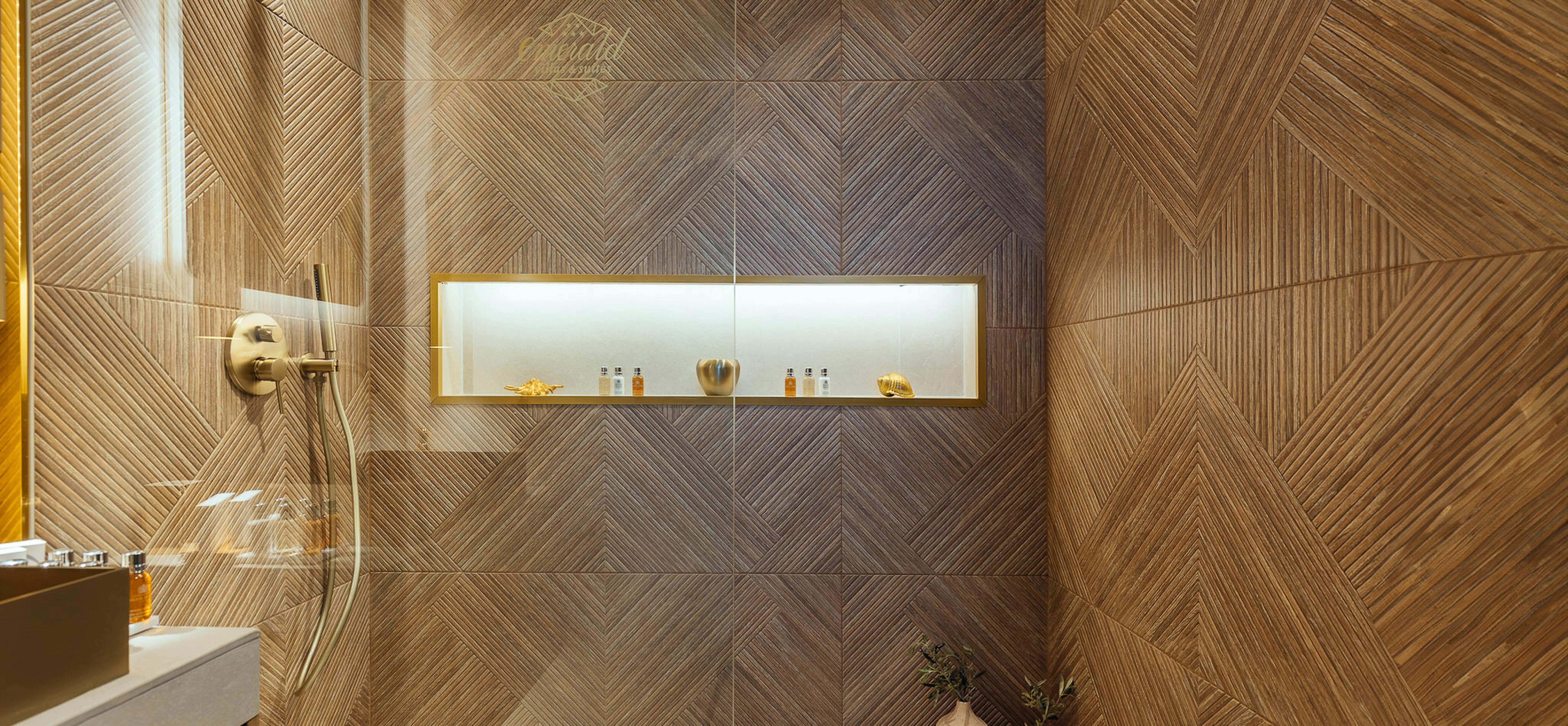 Detailed view of herringbone wood wall pattern with built-in illuminated storage niche and decorative vessels.