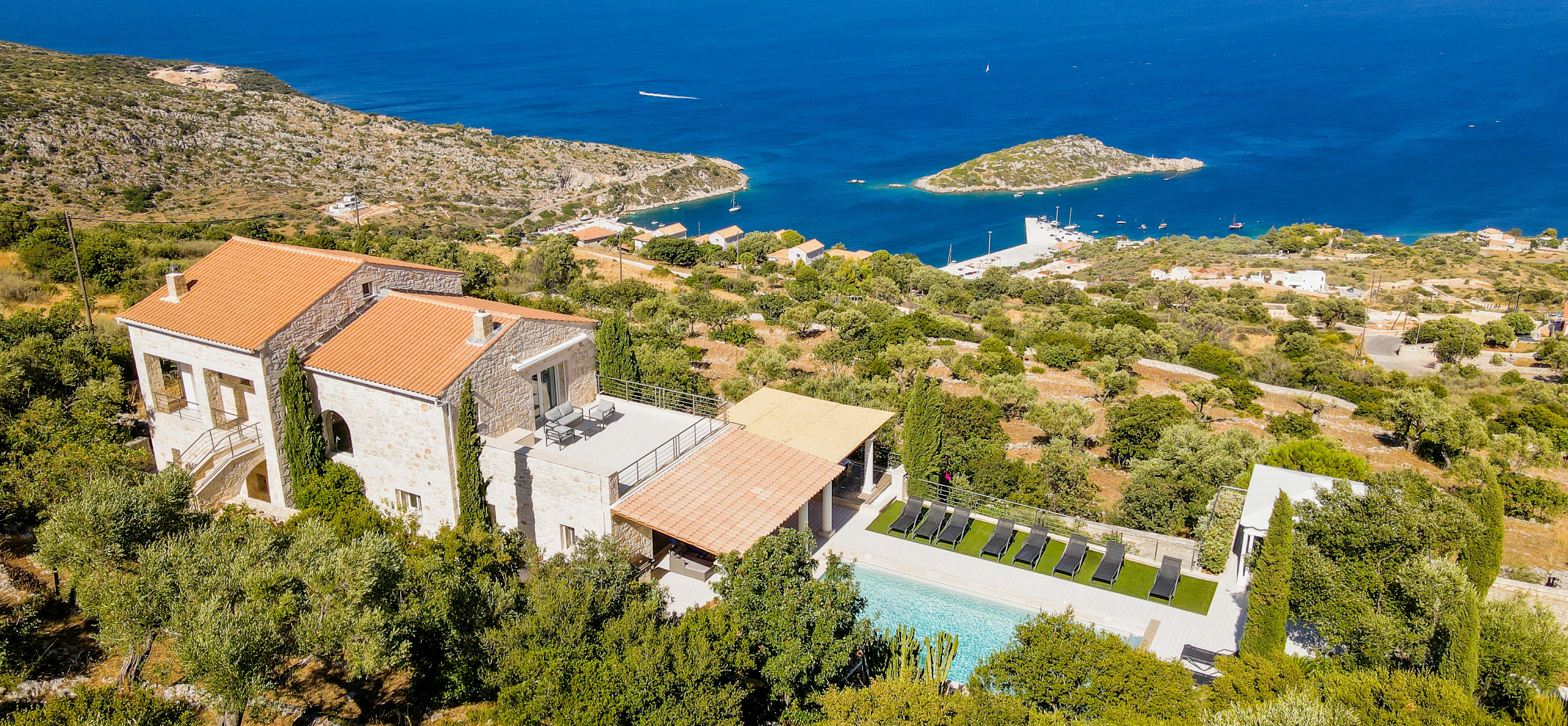 Dramatic coastal villa overlooking turquoise bays with multiple swimming pools and terraced design.