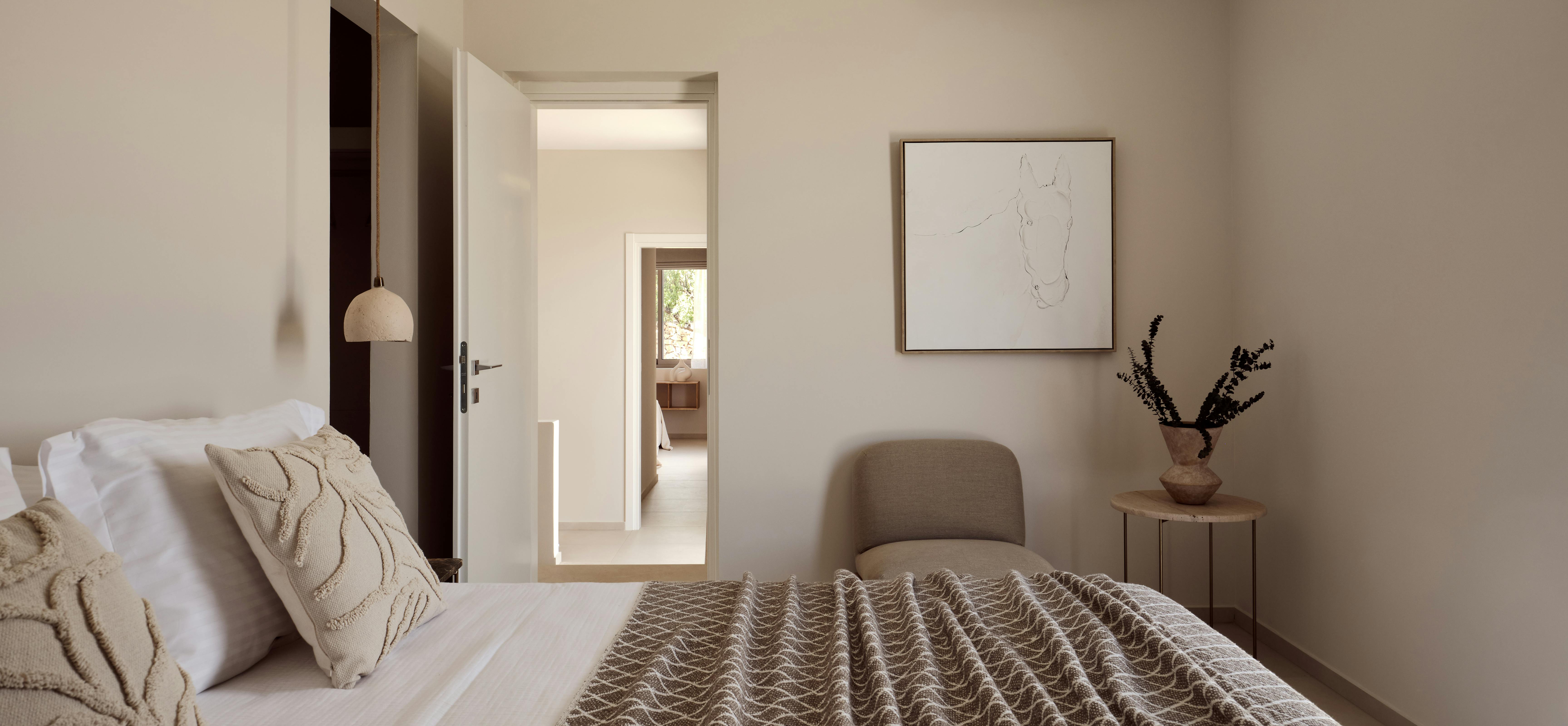 Minimalist bedroom hallway with framed horse sketch, pendant light, and aligned doorways creating layered architectural perspective.