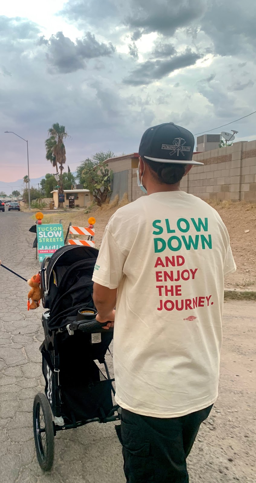 A parent walks with their child in the middle of one of Tucson's new slow streets.