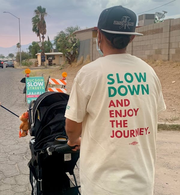 A parent walks with their child in the middle of one of Tucson's new slow streets.