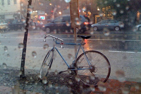A bicycle waits in the rain.