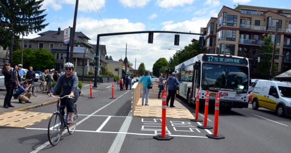 A demonstration of a floating bus stop, built from wood planks by Portland transportation advocates in 2016.