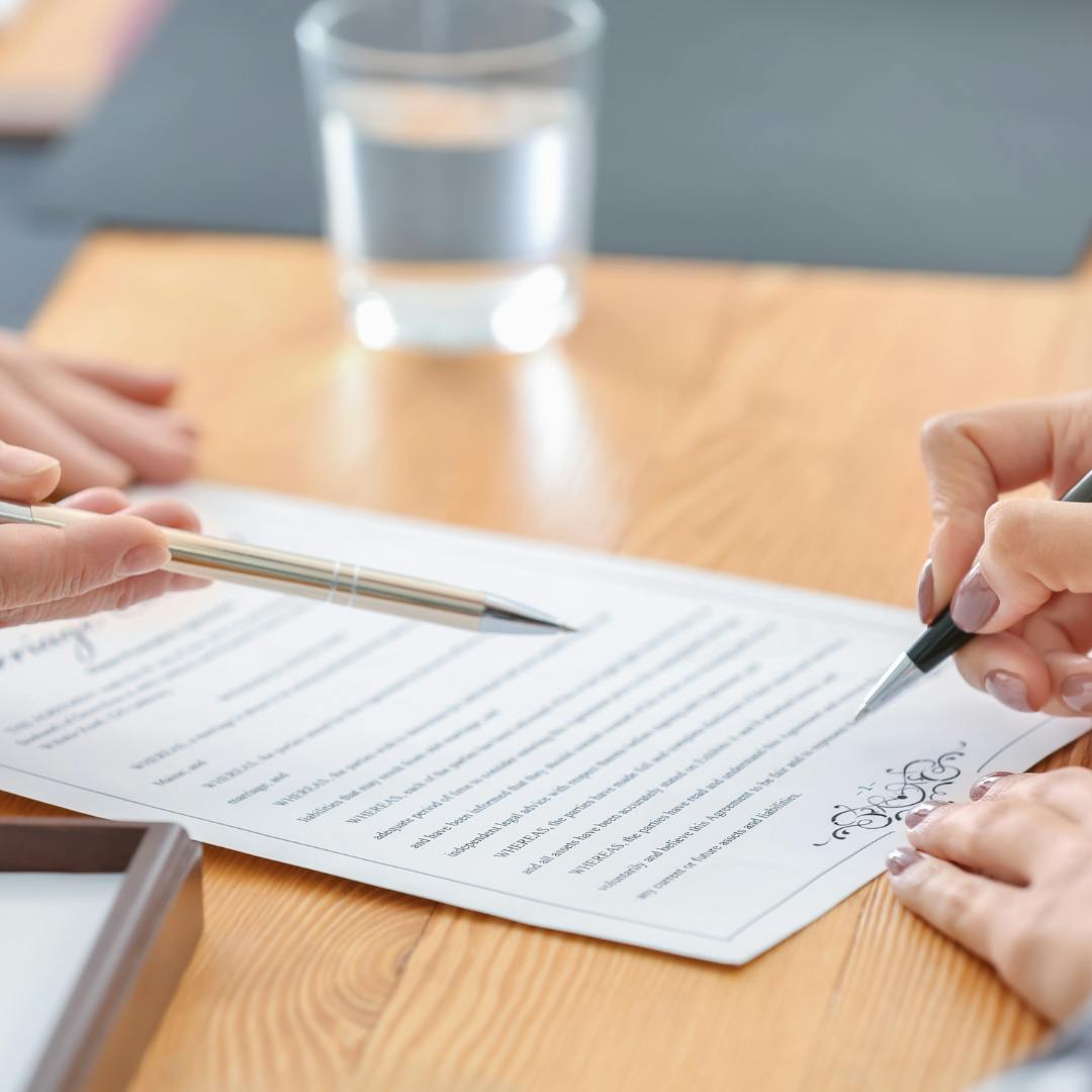 Person happily signing lease agreement for their first apartment - essential steps in renting a new home highlighted in a guide by Perch Apartment Locators