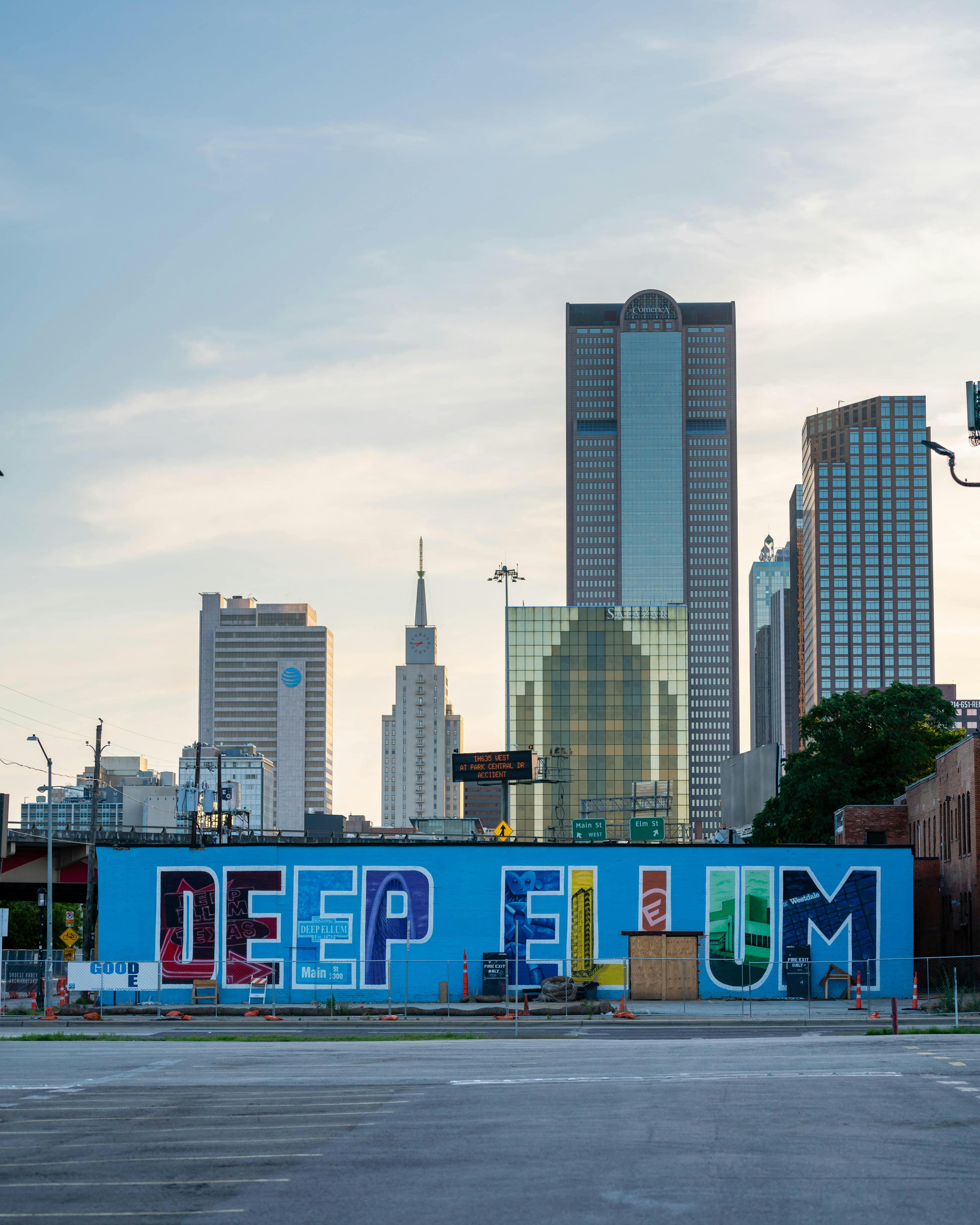 Bustling Deep Ellum neighborhood with colorful murals and street art.