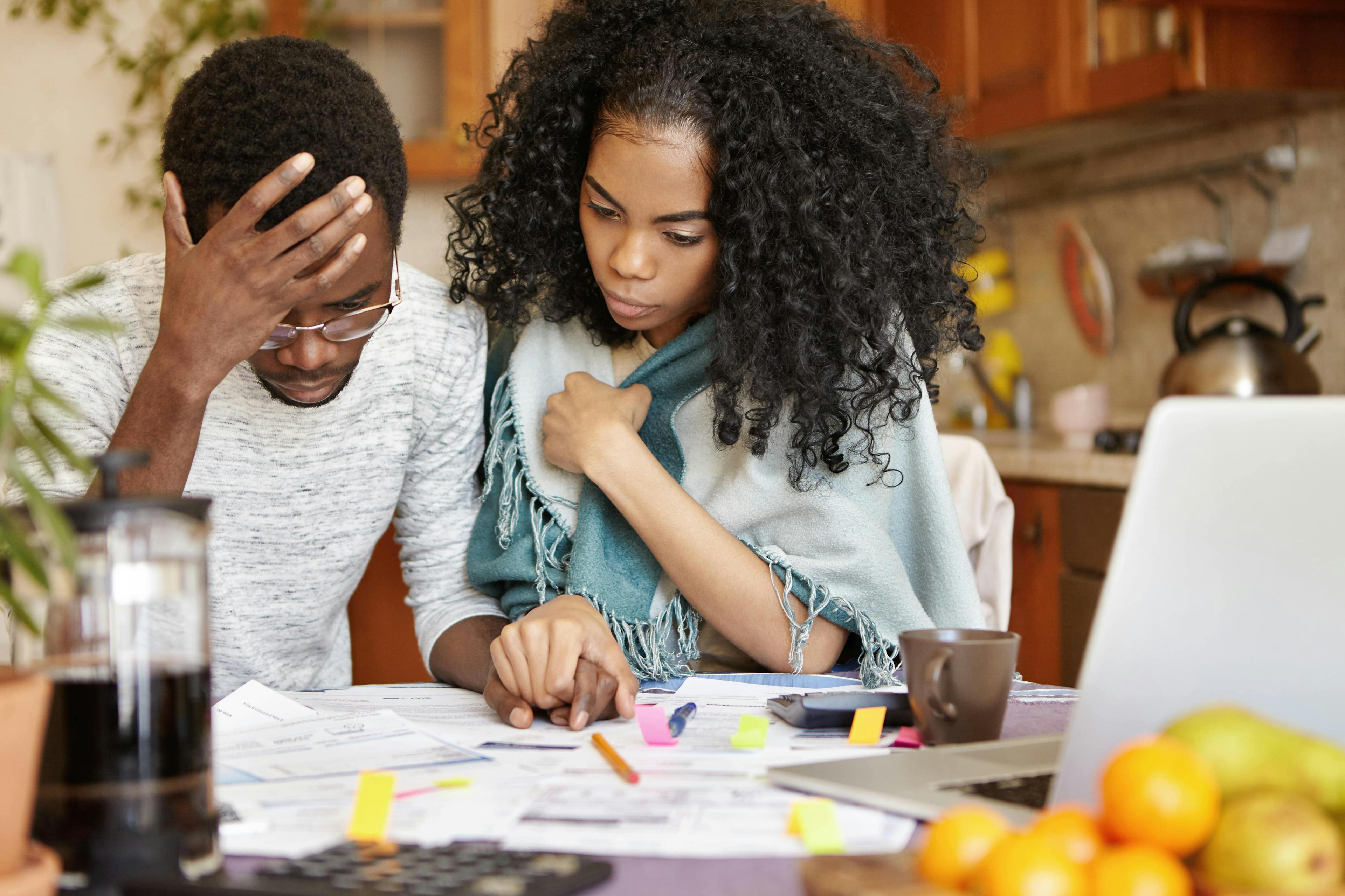 A couple disappointedly looking at their apartment utility bill