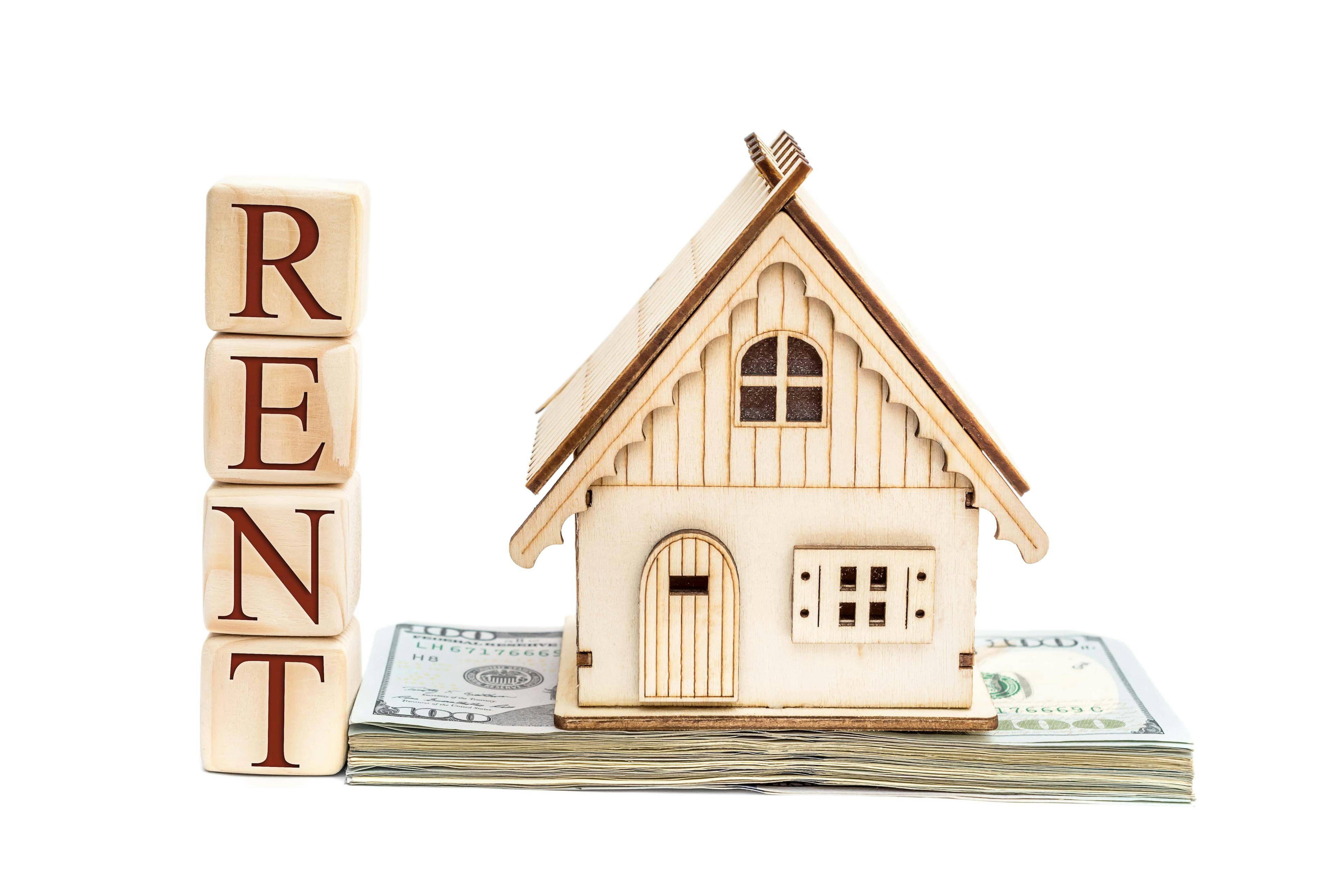 Image of a model of a rental property and wooden blocks that spell "Rent"
