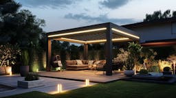 Pergola bioclimatique avec des lumières LED soulignant ses contours, tons neutres, ambiance paisible. La structure est entourée de plantes et de mobilier d'extérieur élégant.