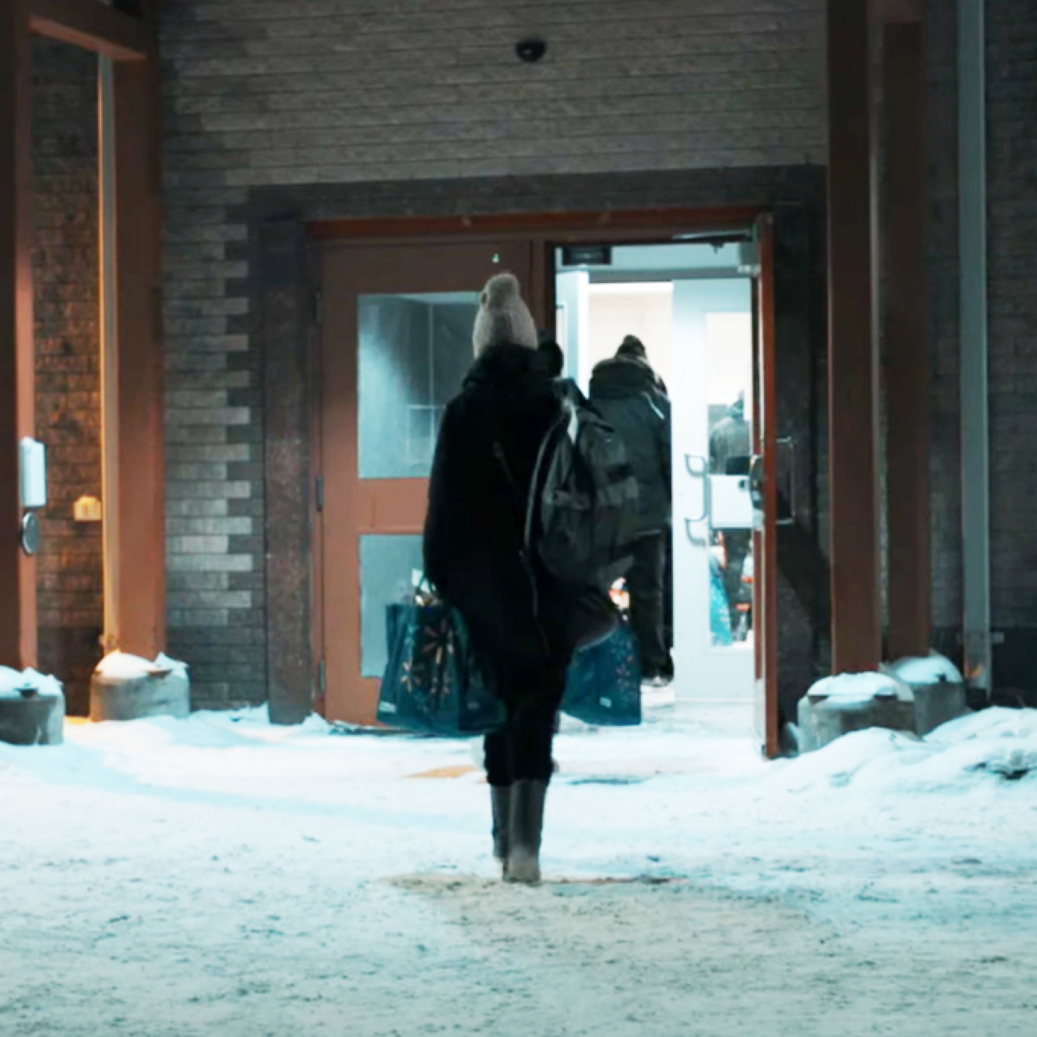 Passenger entering an airport terminal at a Northern Station in the winter.