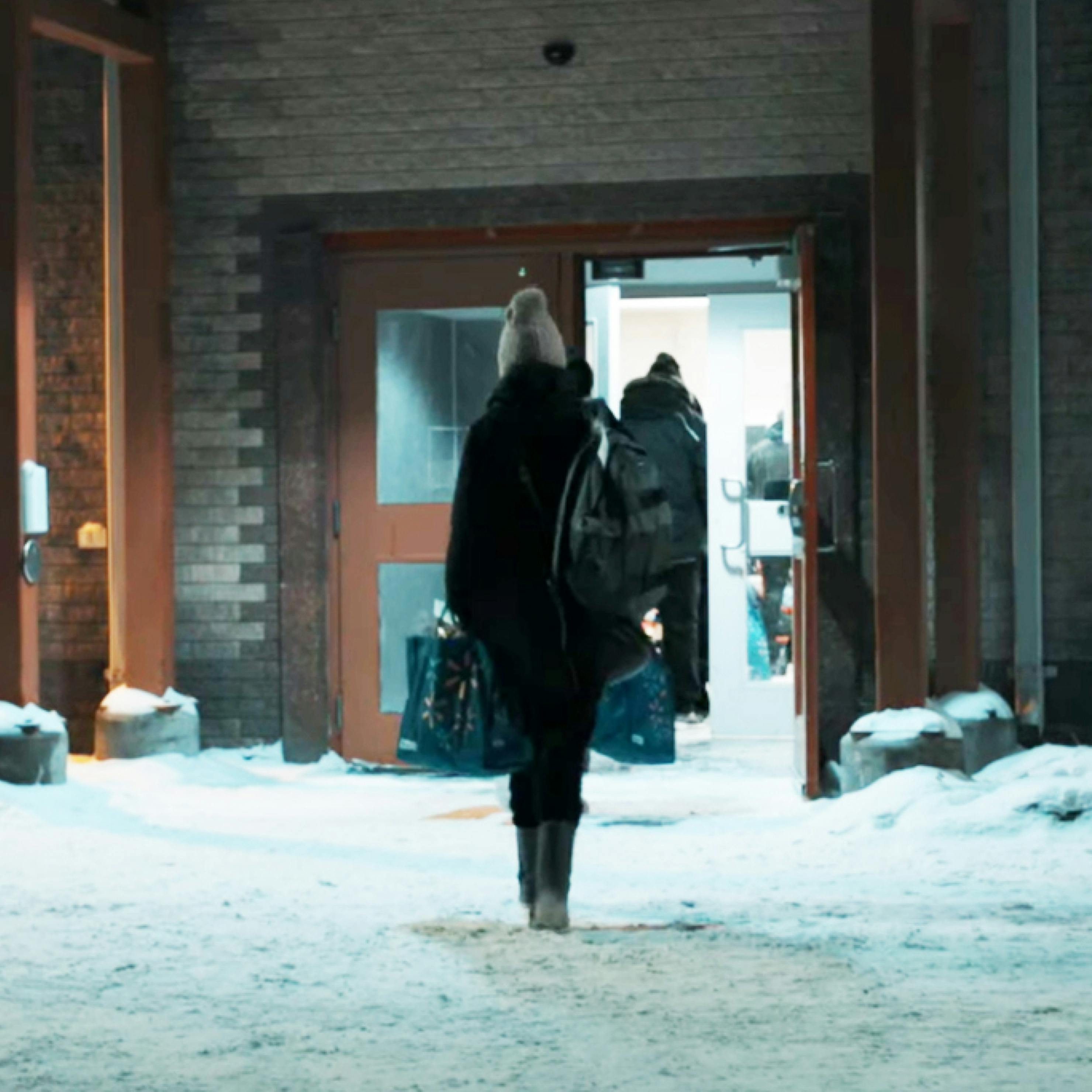 Passenger entering an airport terminal at a Northern Station in the winter.