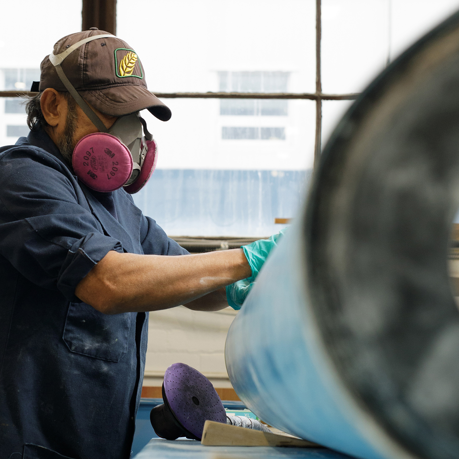 Line maintenance personnel sanding aircraft part.