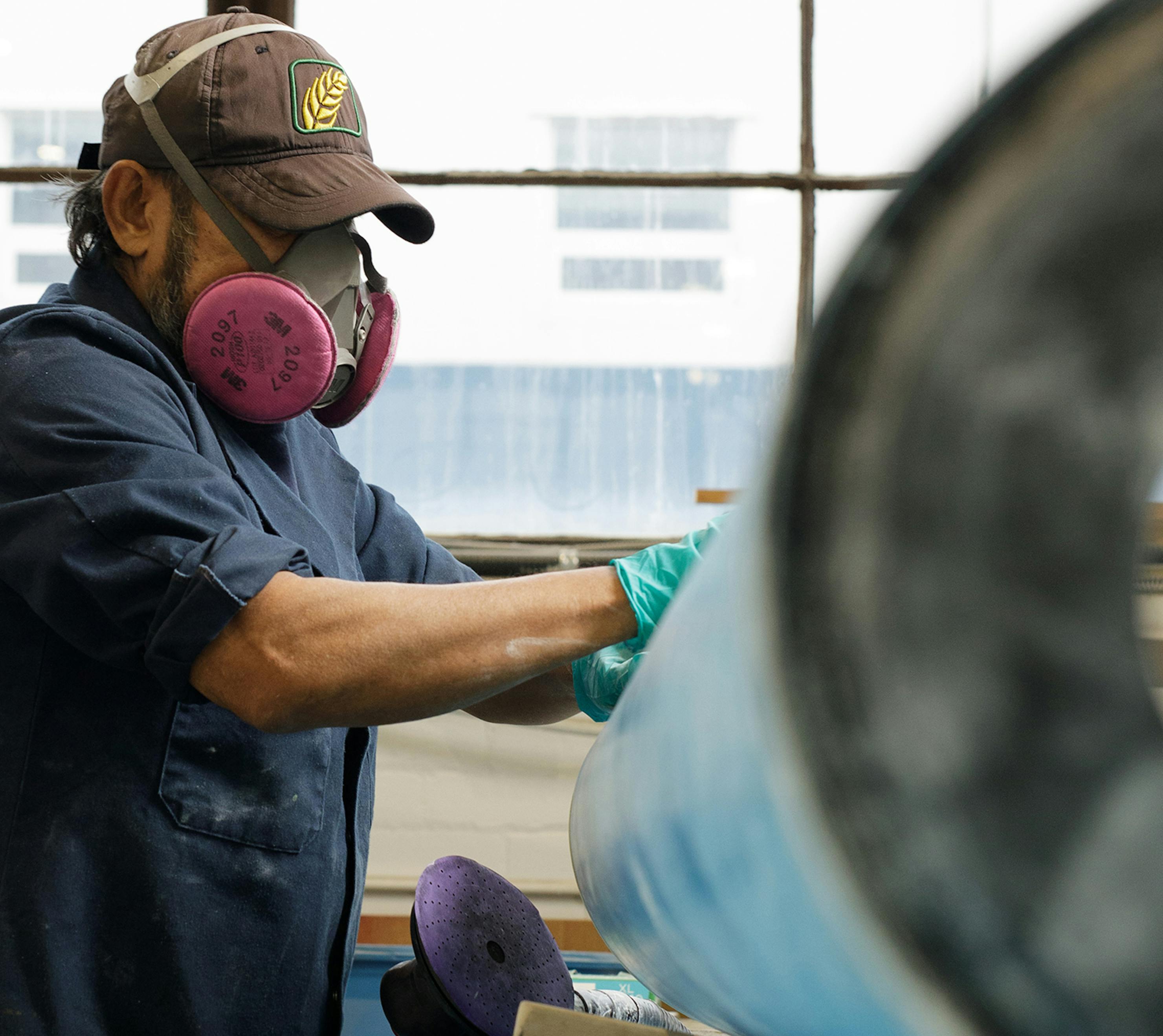 Line maintenance personnel sanding aircraft part.