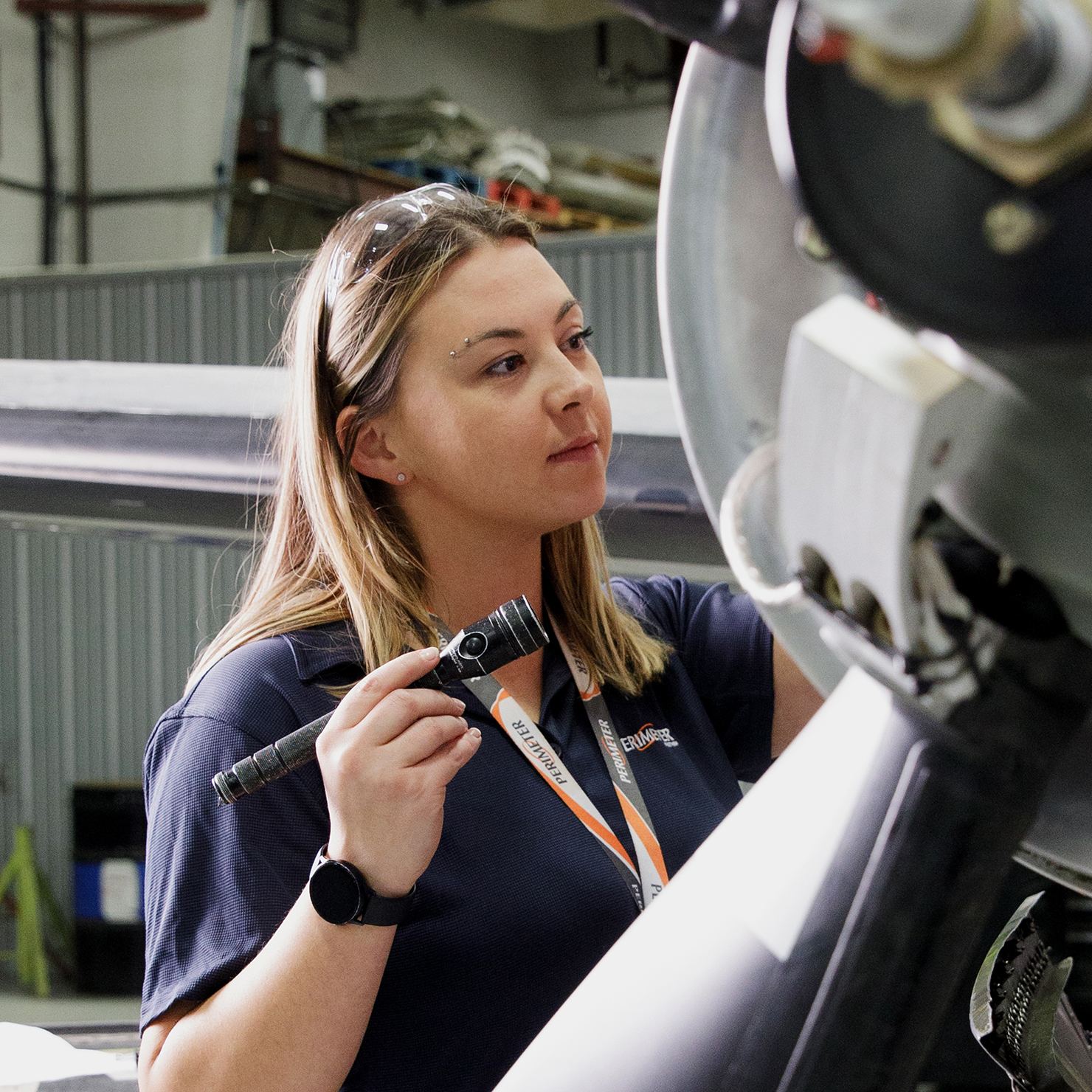 Woman inspecting airplane engine.