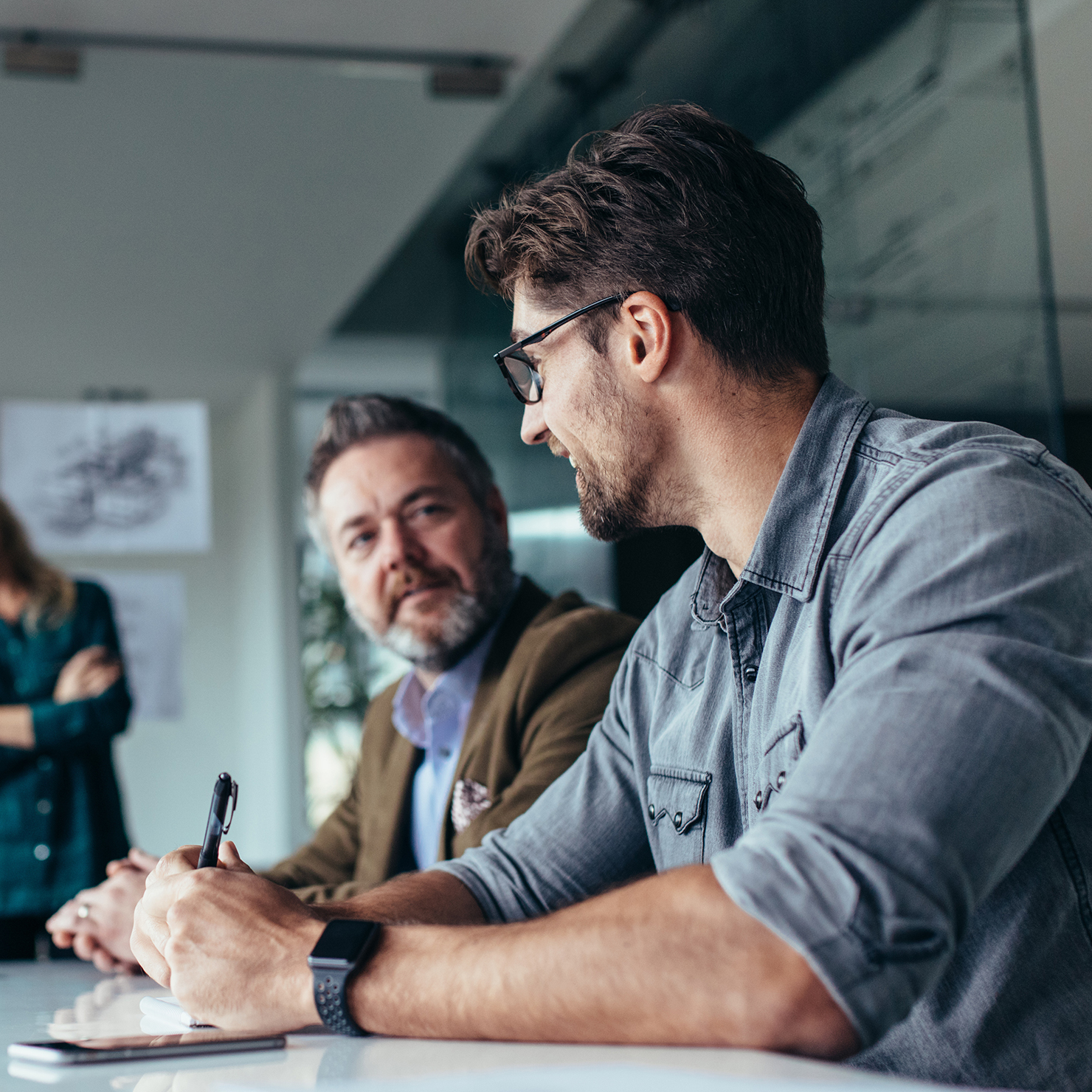 Two men in boardroom laughing and chatting.