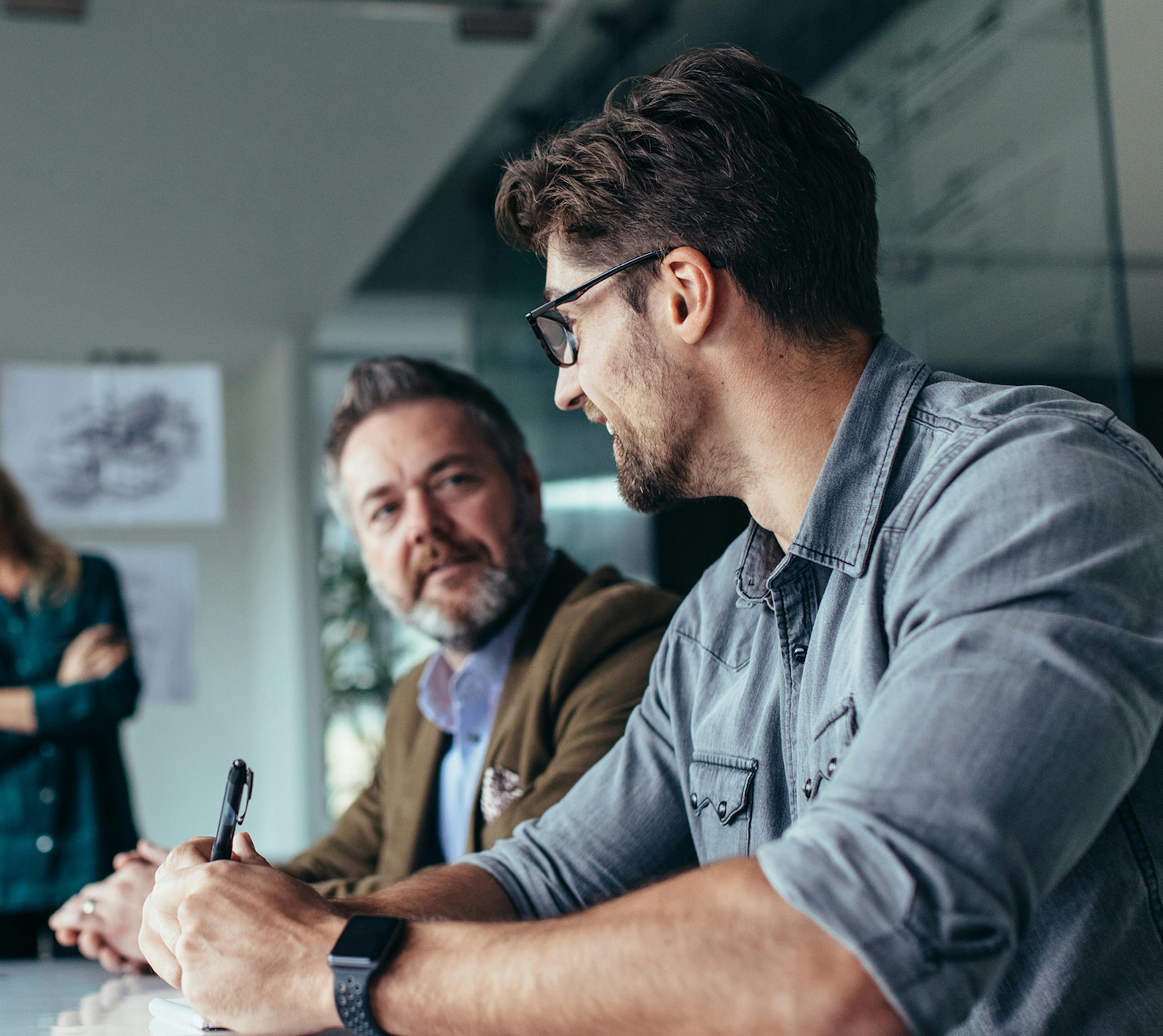 Two men in boardroom laughing and chatting.