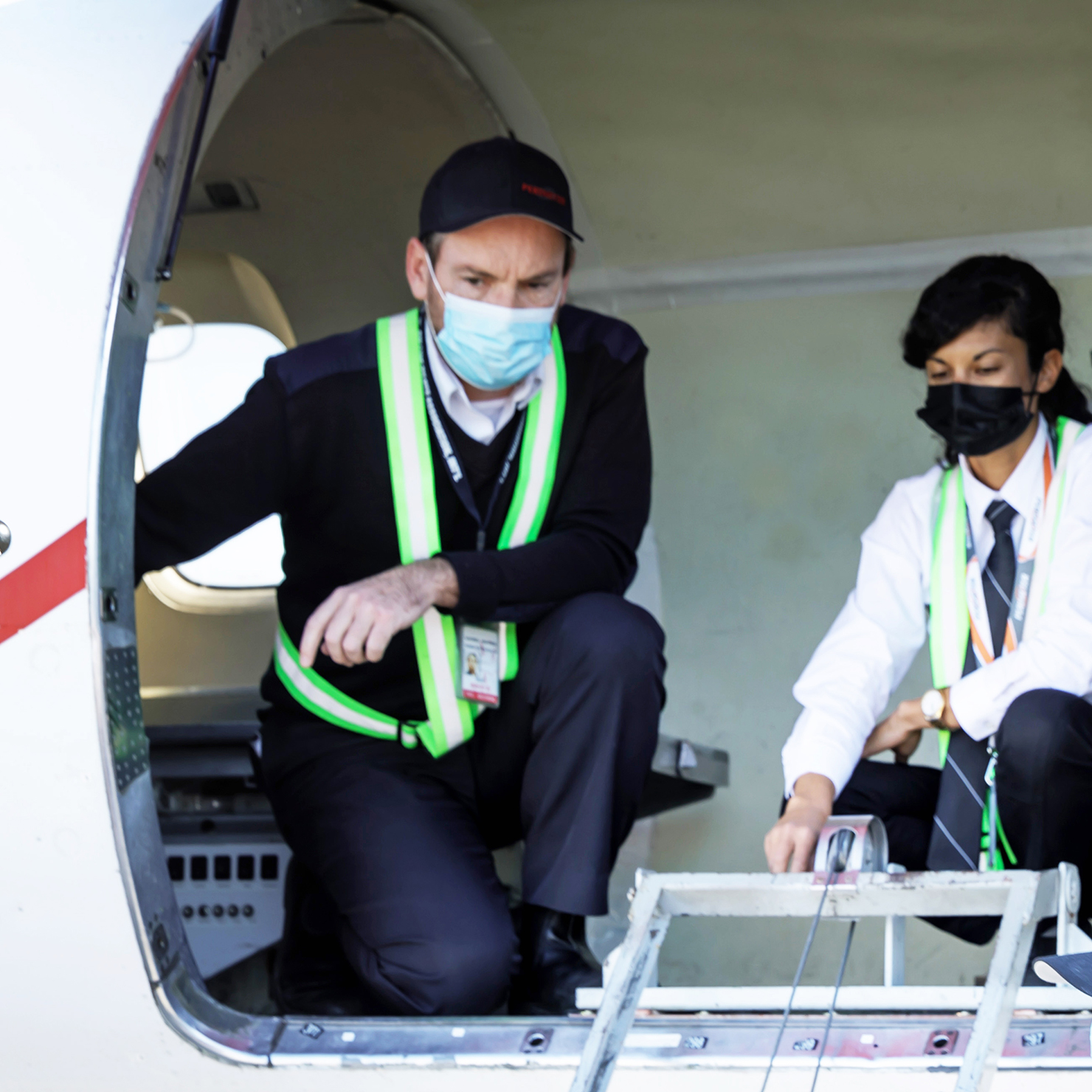 Medevac pilots preparing for patient to be lifted into aircraft.