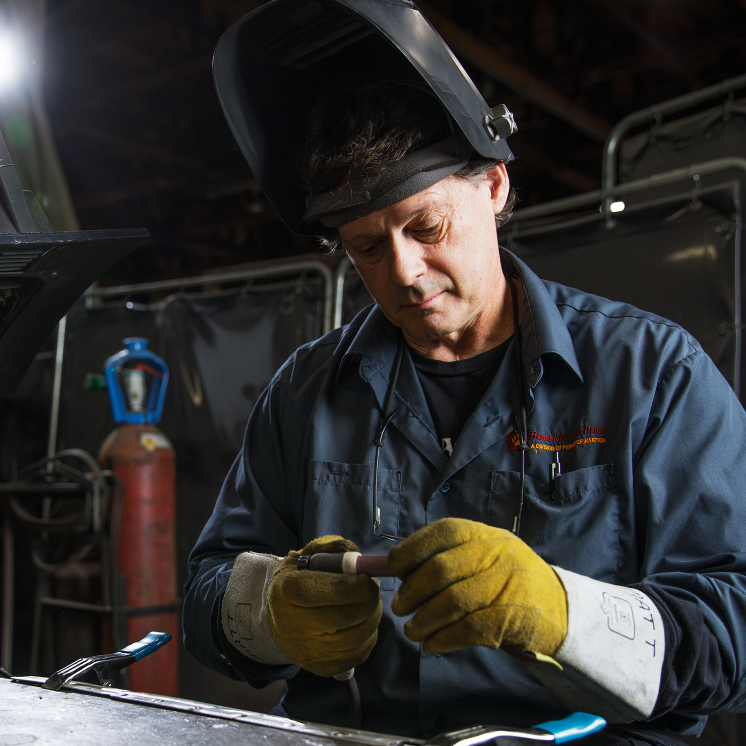 Man working at a table with welding tools.