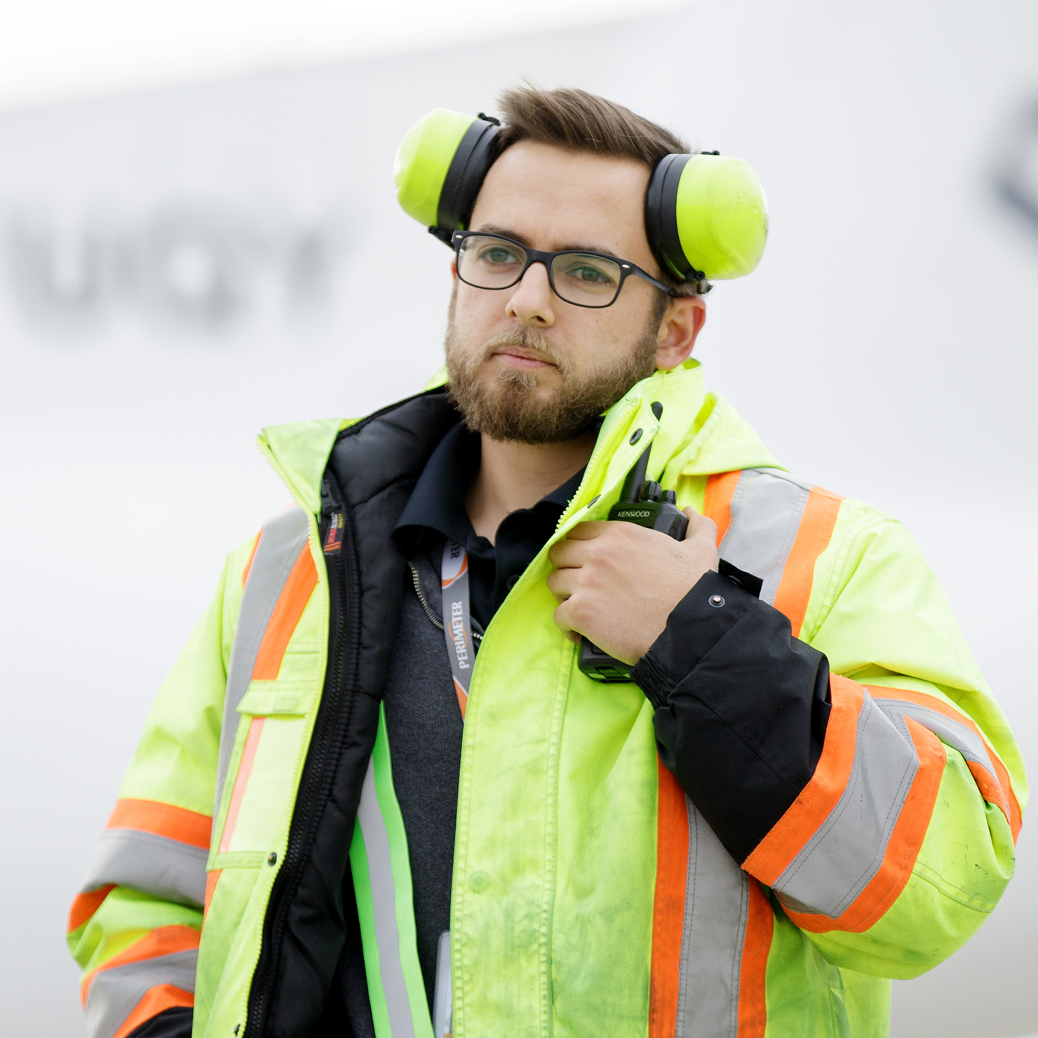 Ramp manager holding holding radio and looking into the distance.