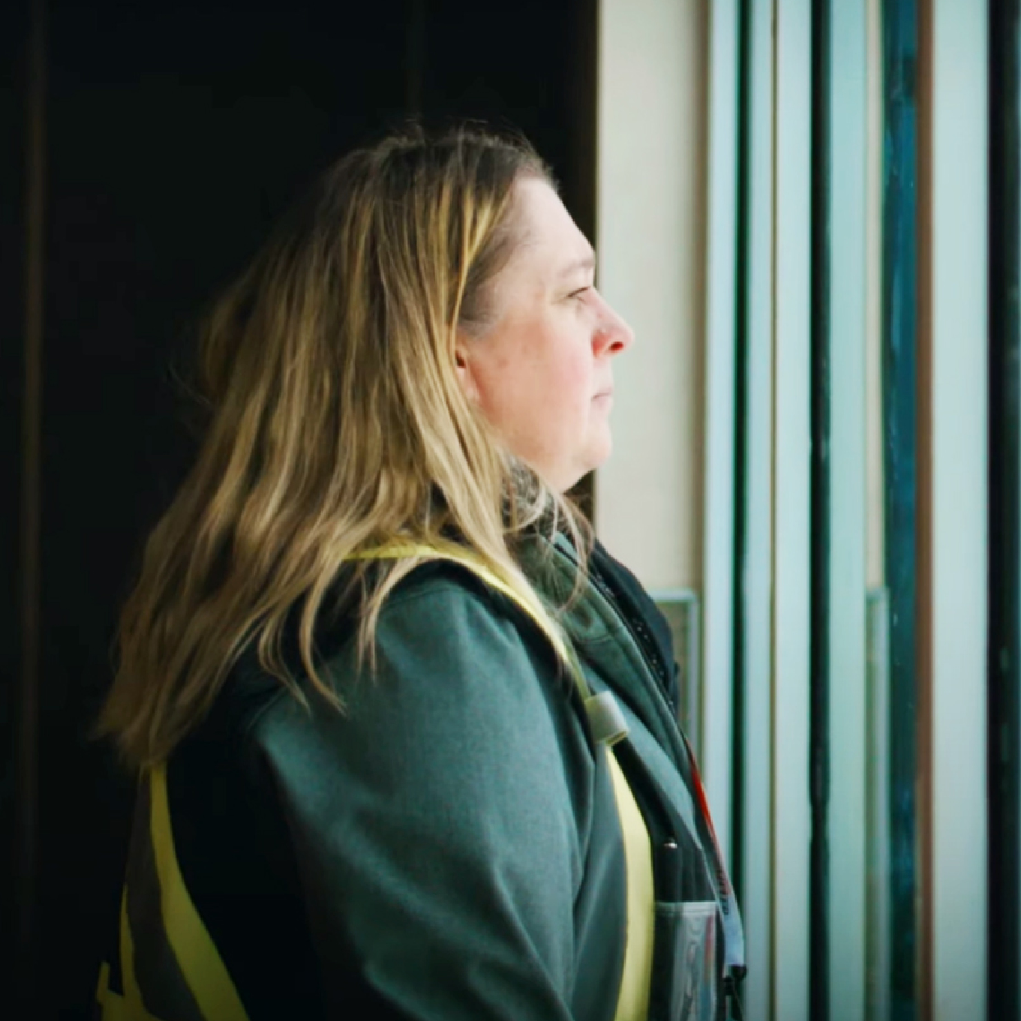 Woman looking out the window at an airport.