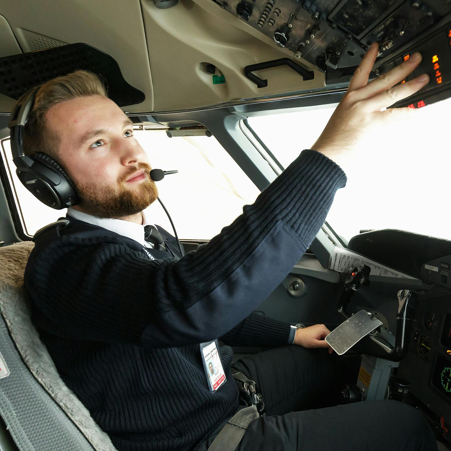 Pilot turning on controls in the cockpit of an airplane.