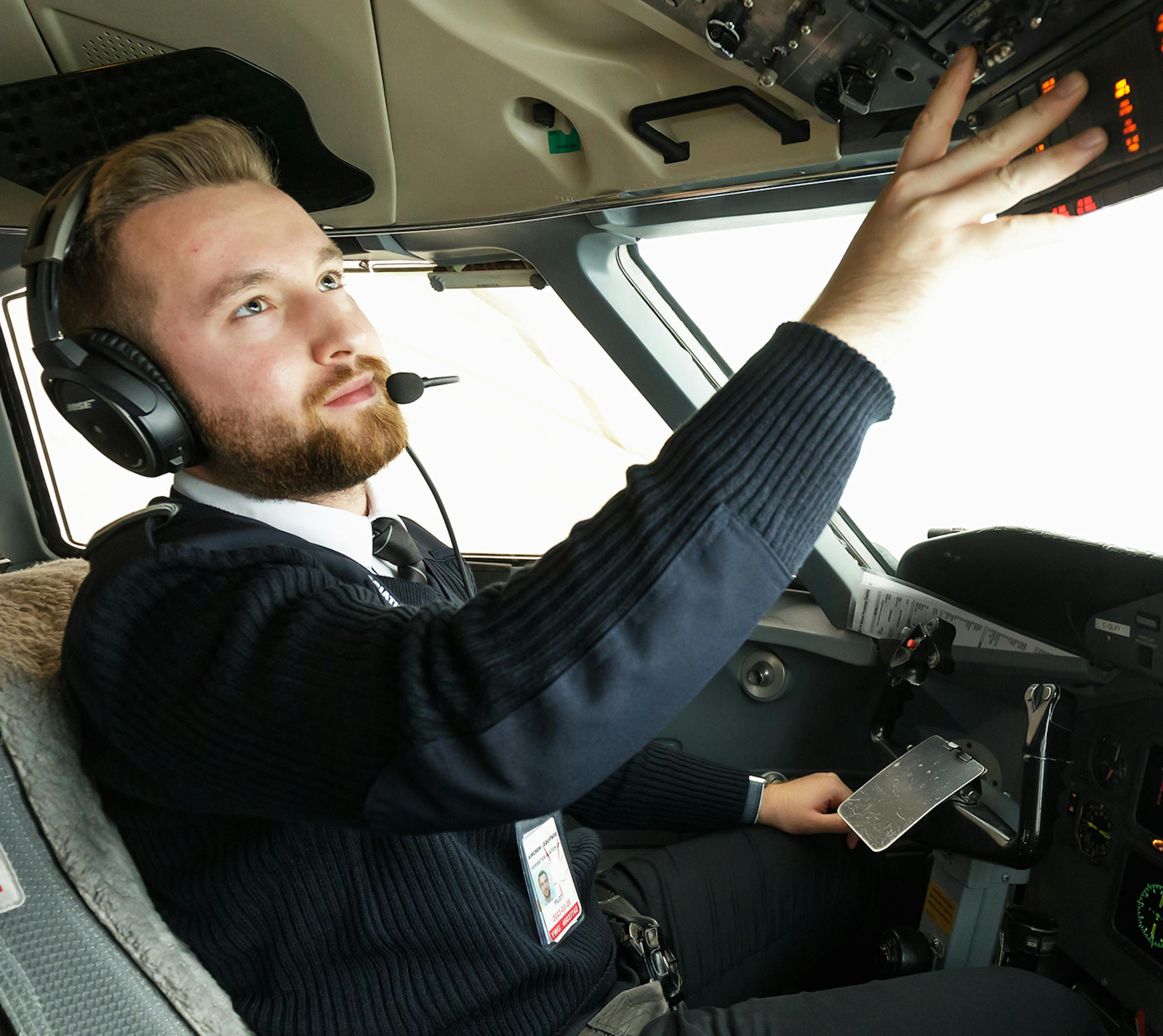 Pilot turning on controls in the cockpit of an airplane.