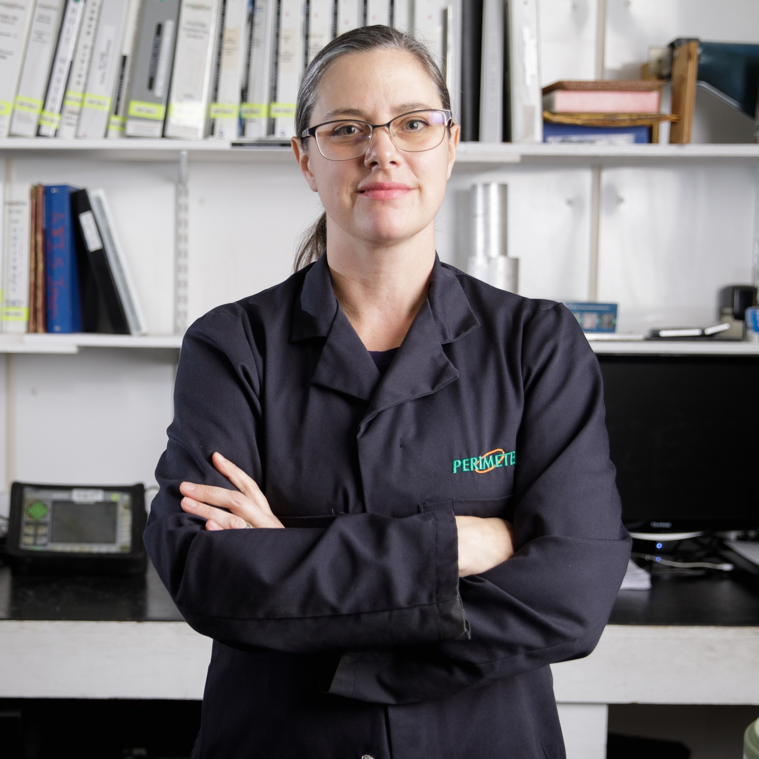 Female NDT technician standing with arms crossed in the work shop.