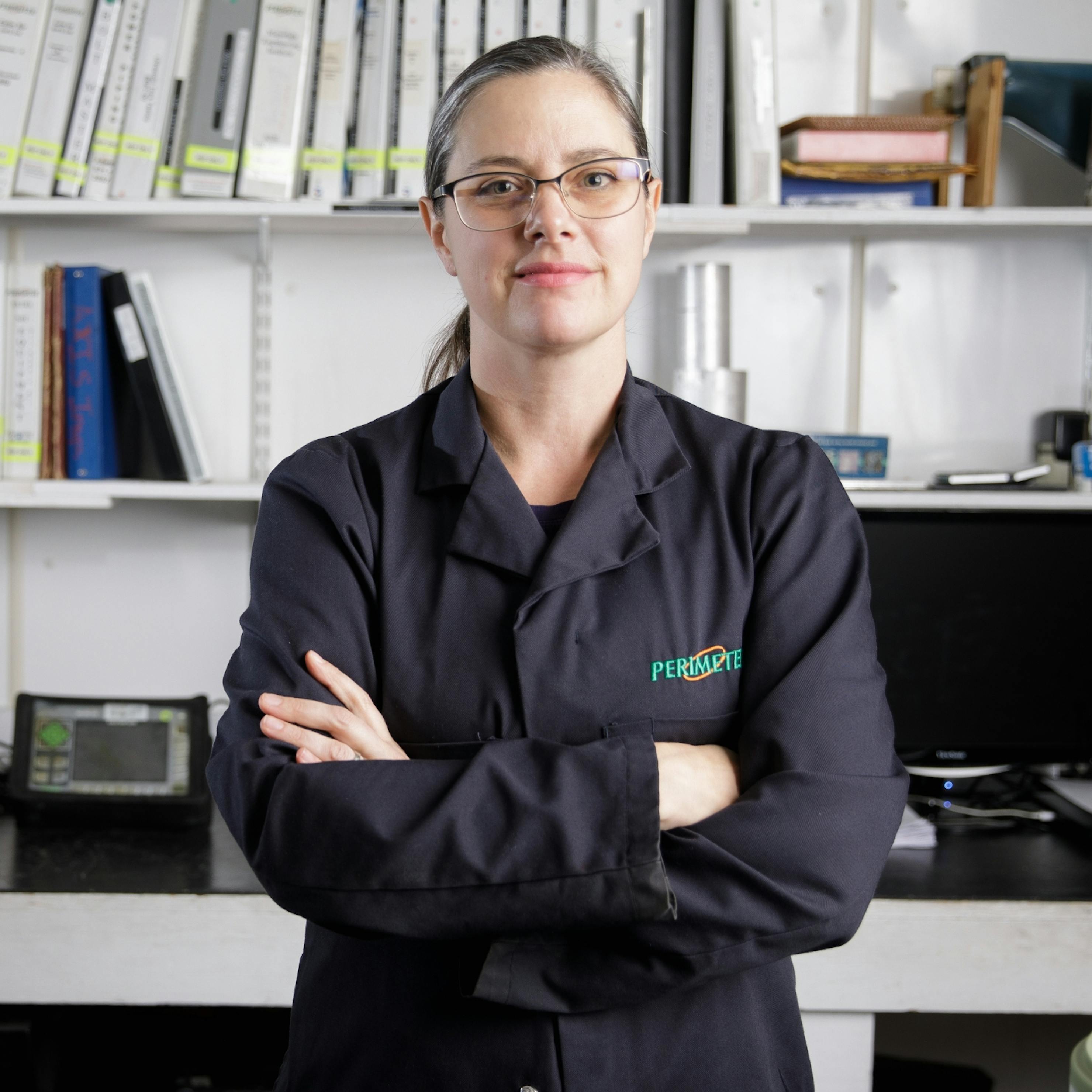 Female NDT technician standing with arms crossed in the work shop.