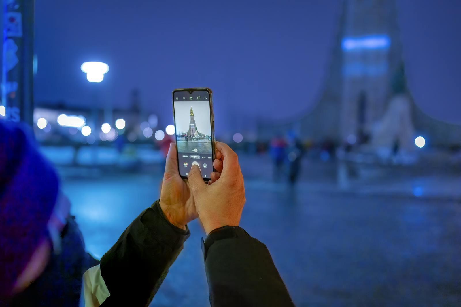 Man taking a photo of Hallgrimskirkja in Reykjavik