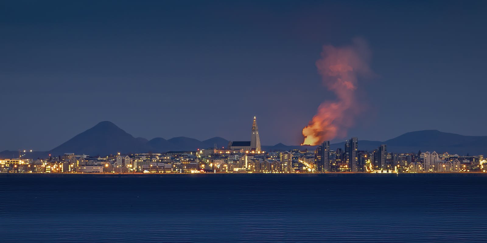 Skyline of Reykjavik with volcano eruption in background