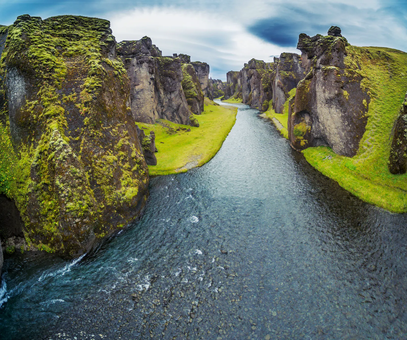fjaðrárglúfur canyon in the summer with water and green moss