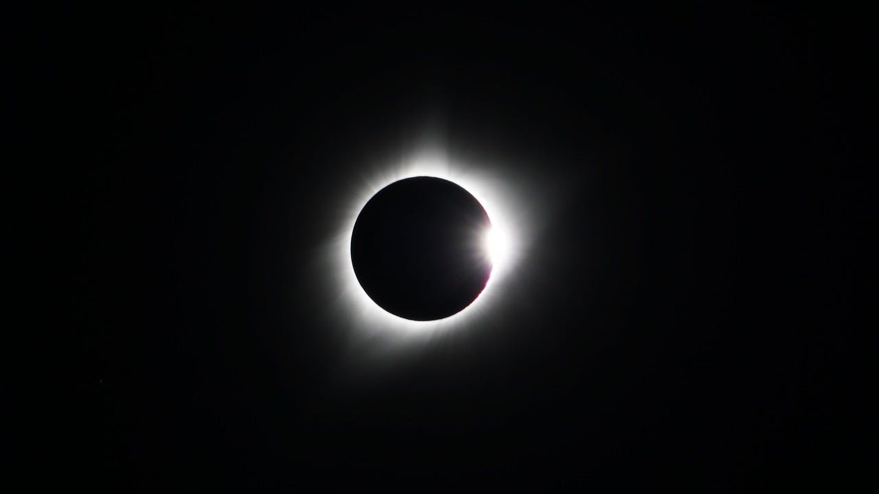 total solar eclipse with a white glow on a black background