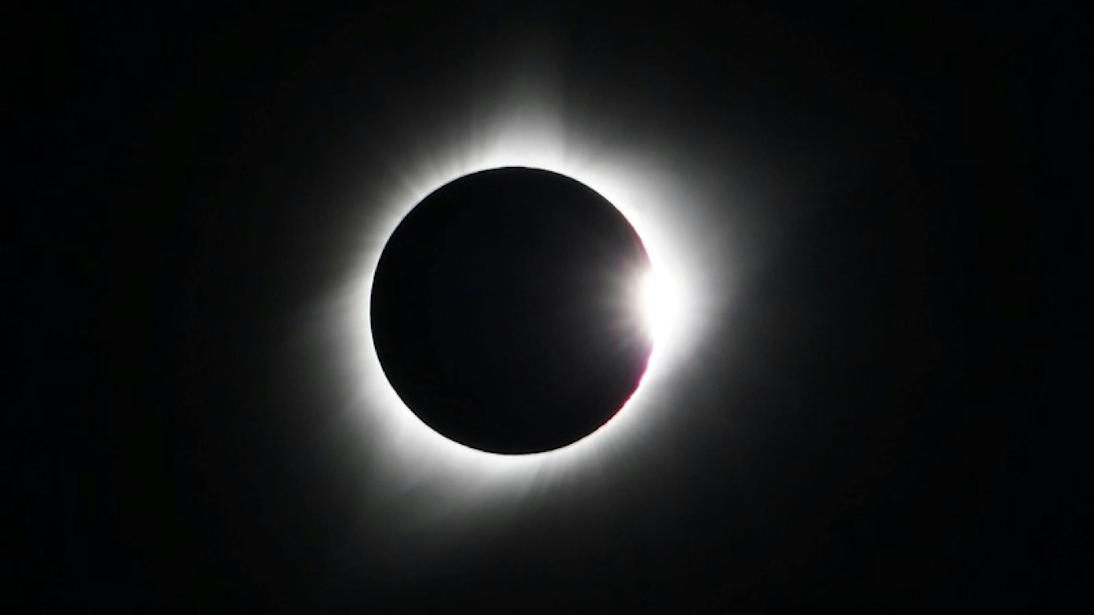 total solar eclipse with a white glow on a black background