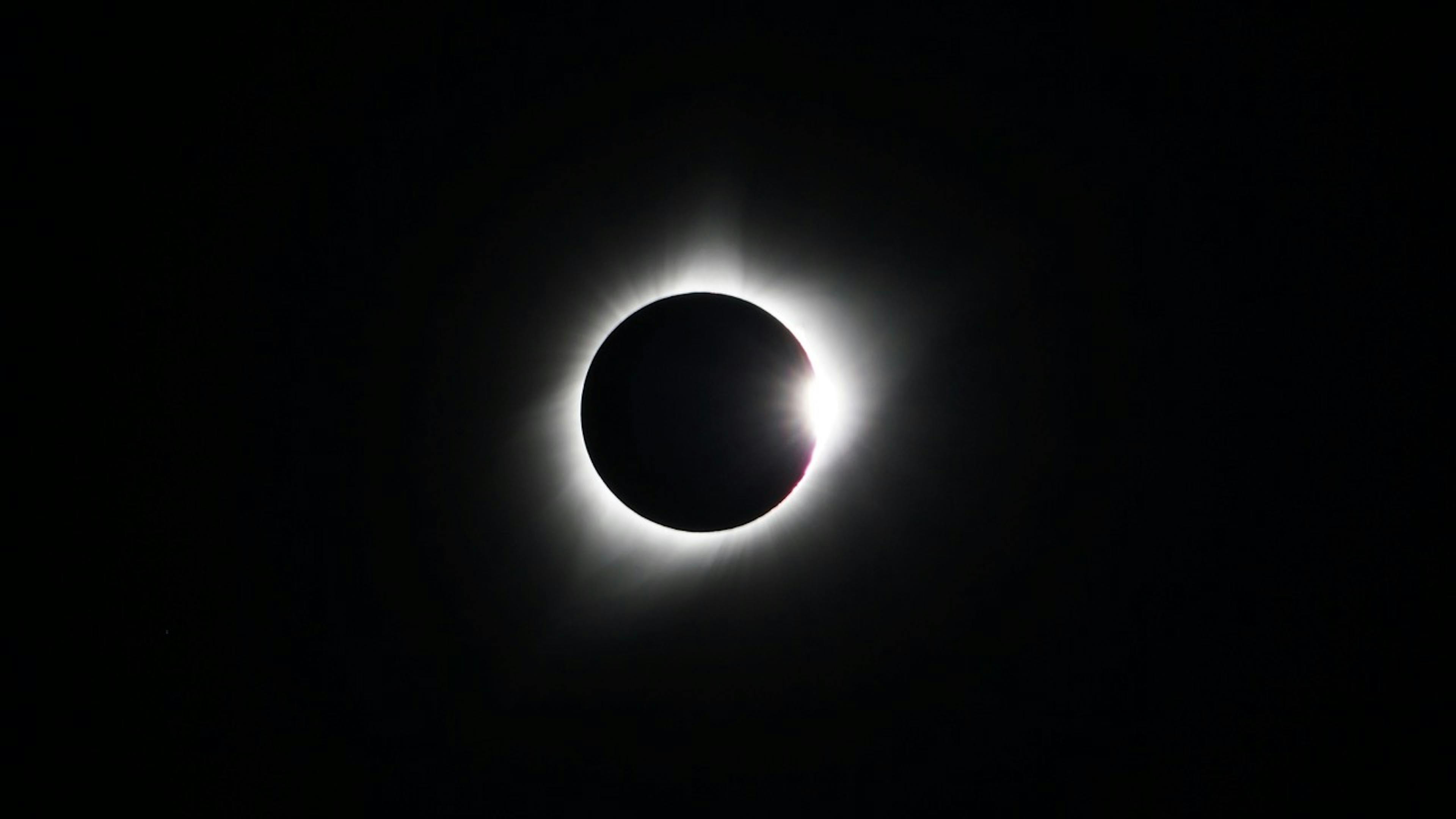 total solar eclipse with a white glow on a black background