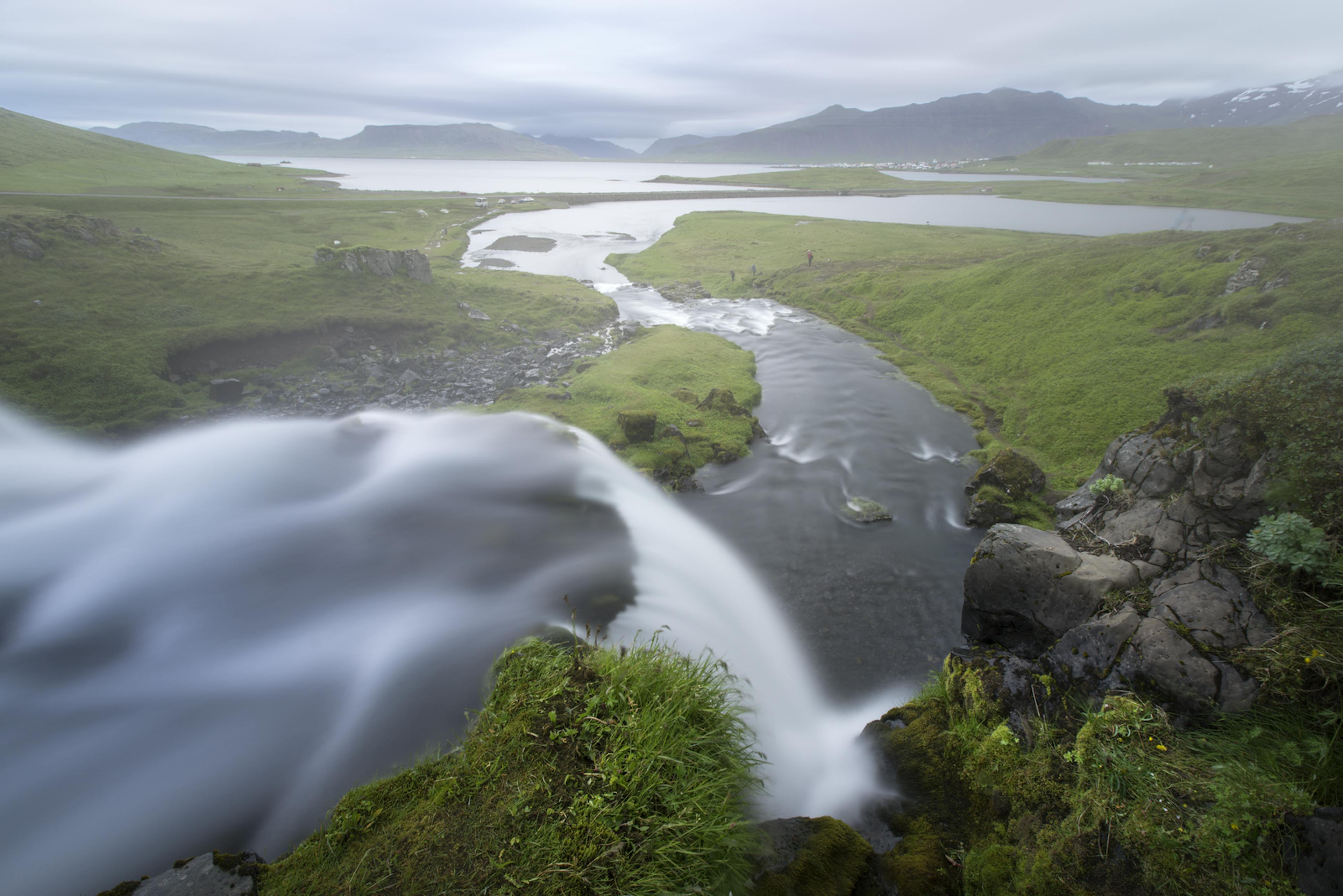 Kirkjufellsfoss Waterfall in the summertime with lush greenery