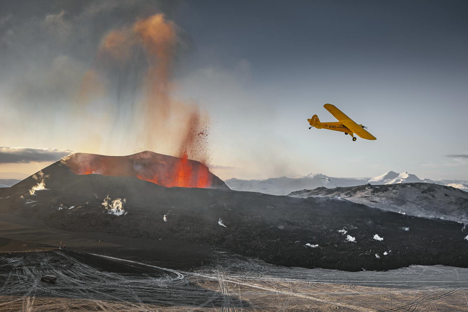 airplan flying over eruption by fimmvörðuháls