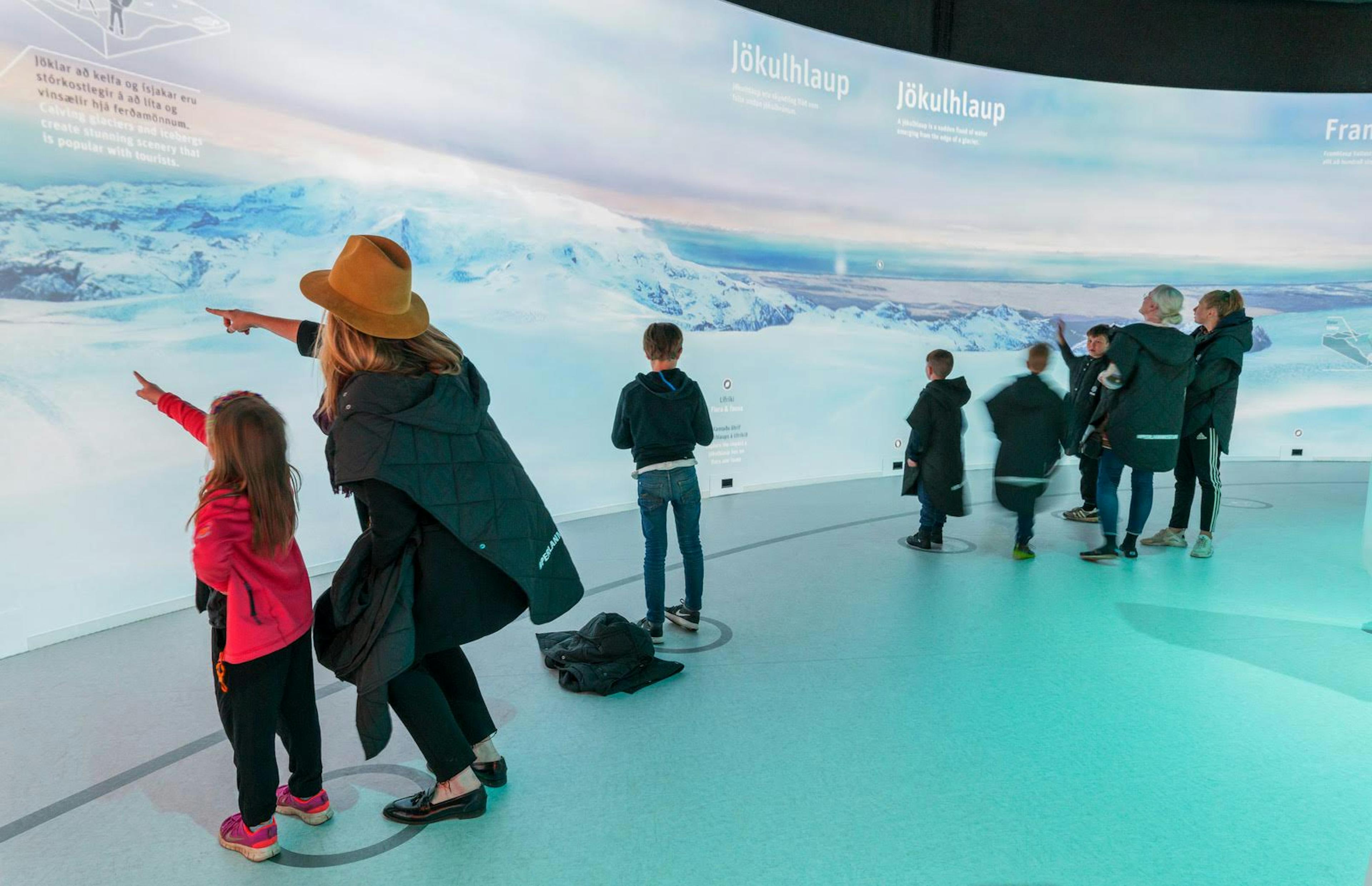 Tourists interacting with glacier exhibit in Reykjavík