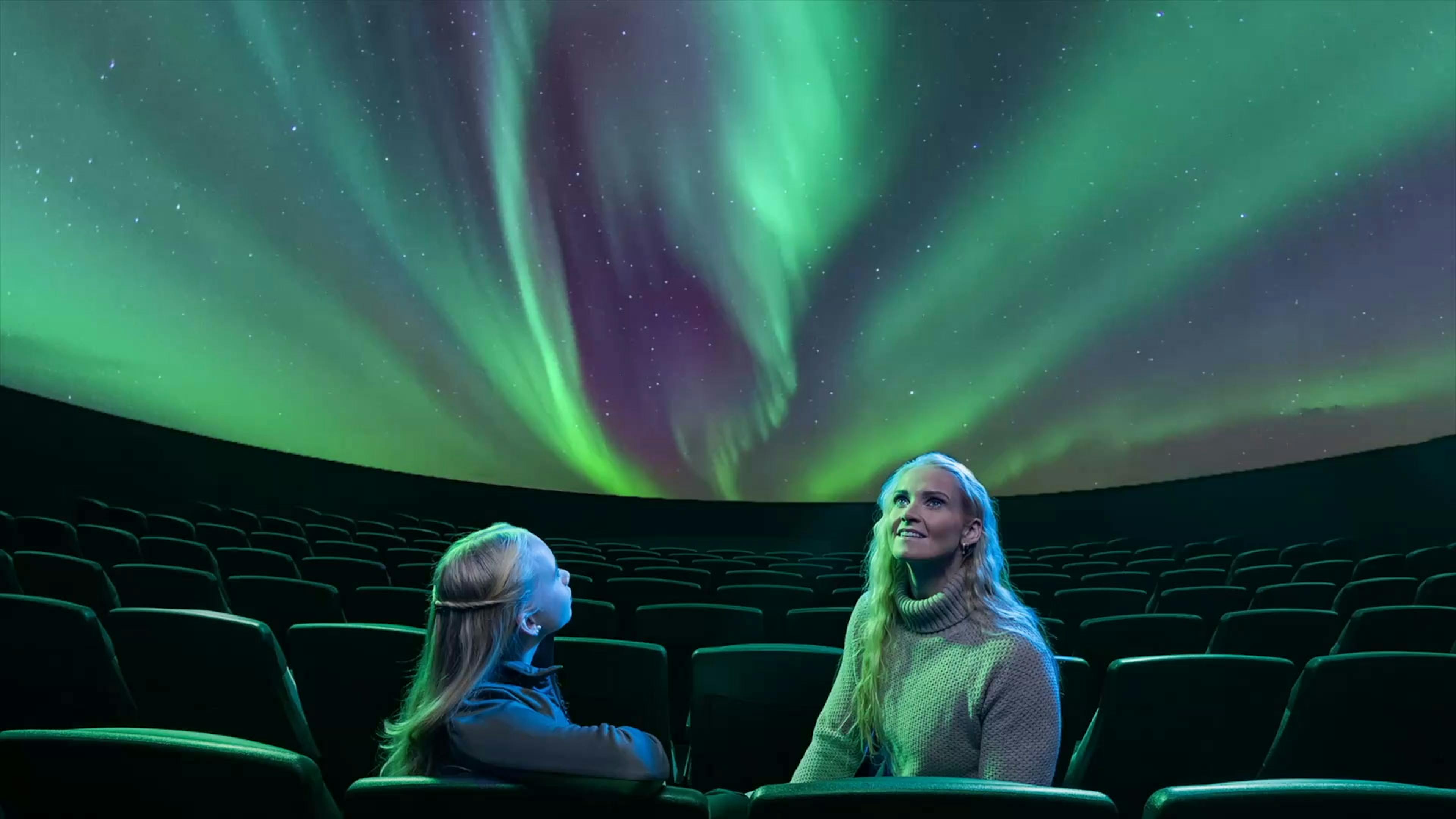 a mom and daughter watching the northern lights show in Reykjavík