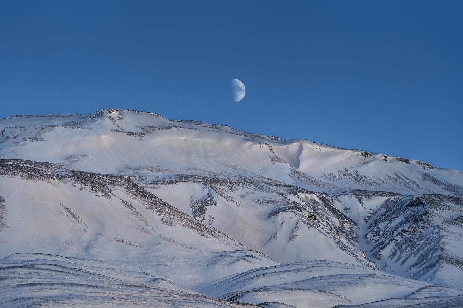 þórólfsfell covered in snow with the moon in the background