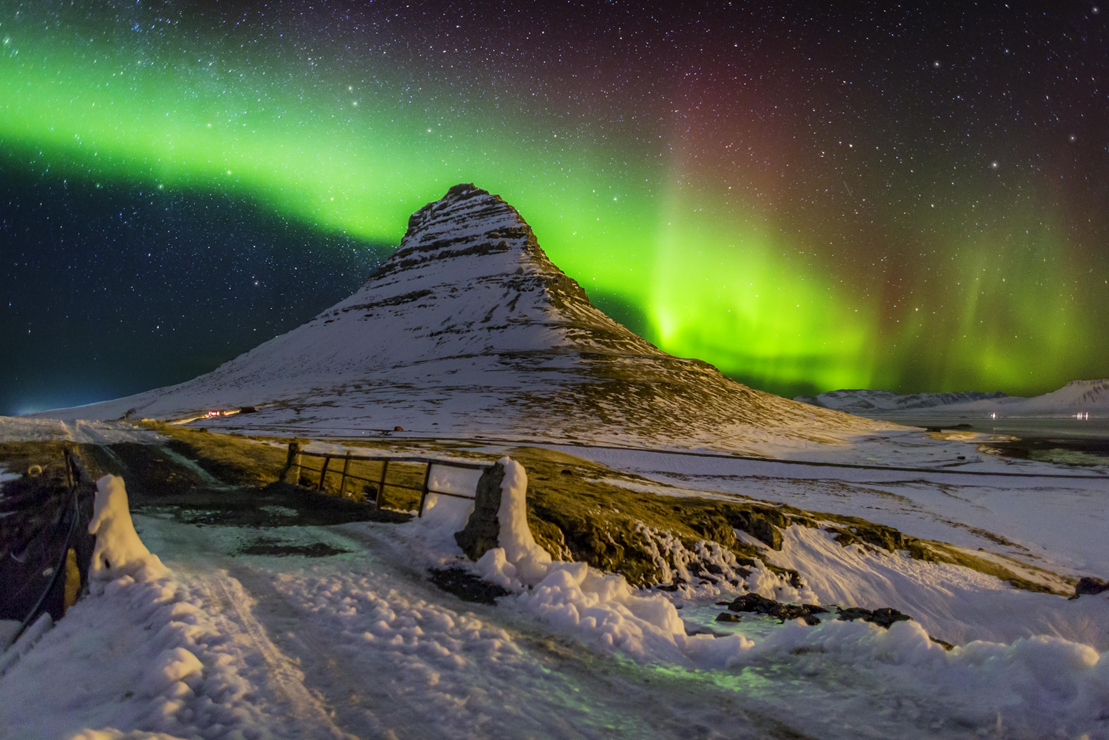 Snow-covered Kirkjufell mountain with the northern lights in the sky