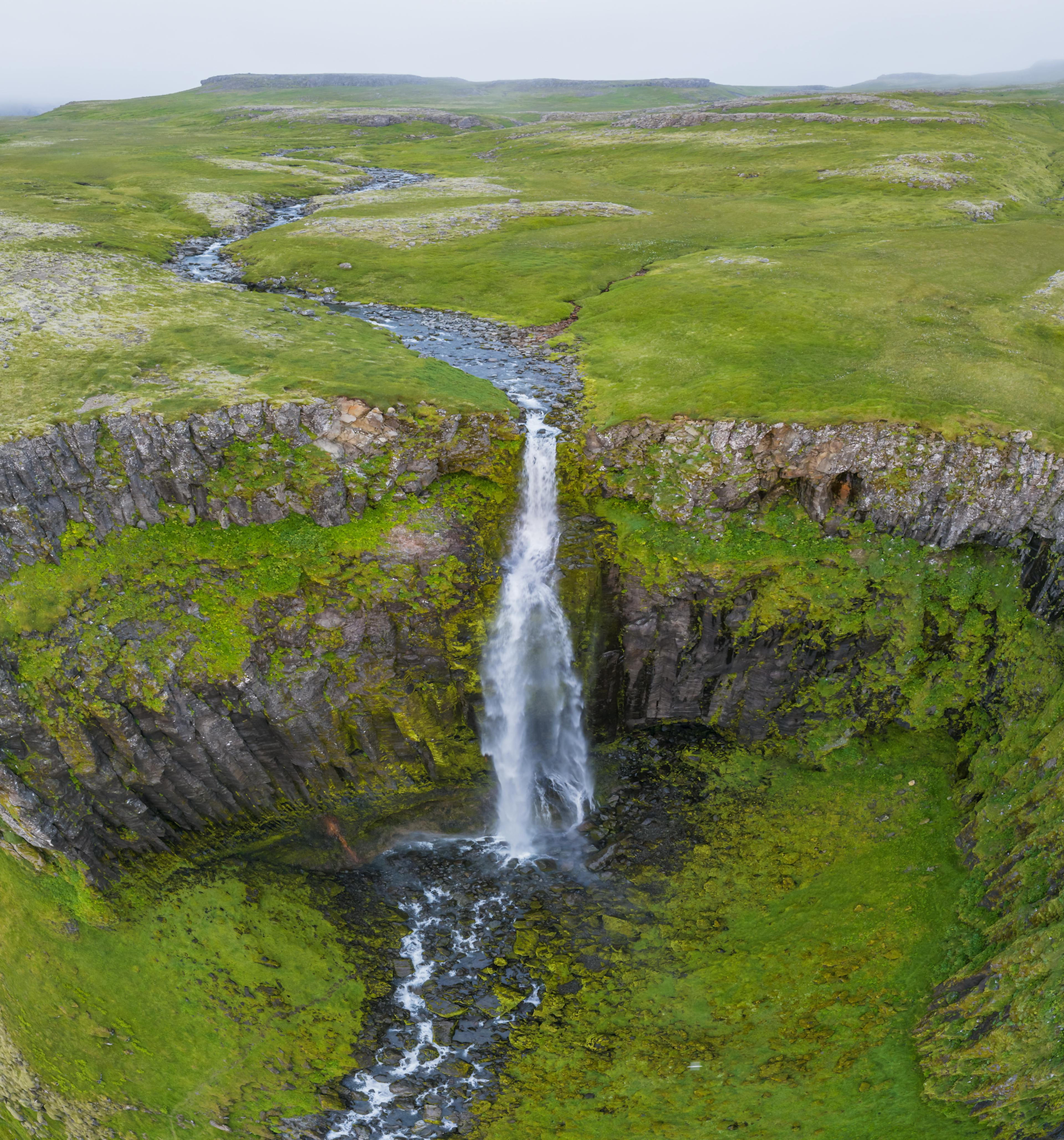 An aerial view of Svöðufoss with greenery all around
