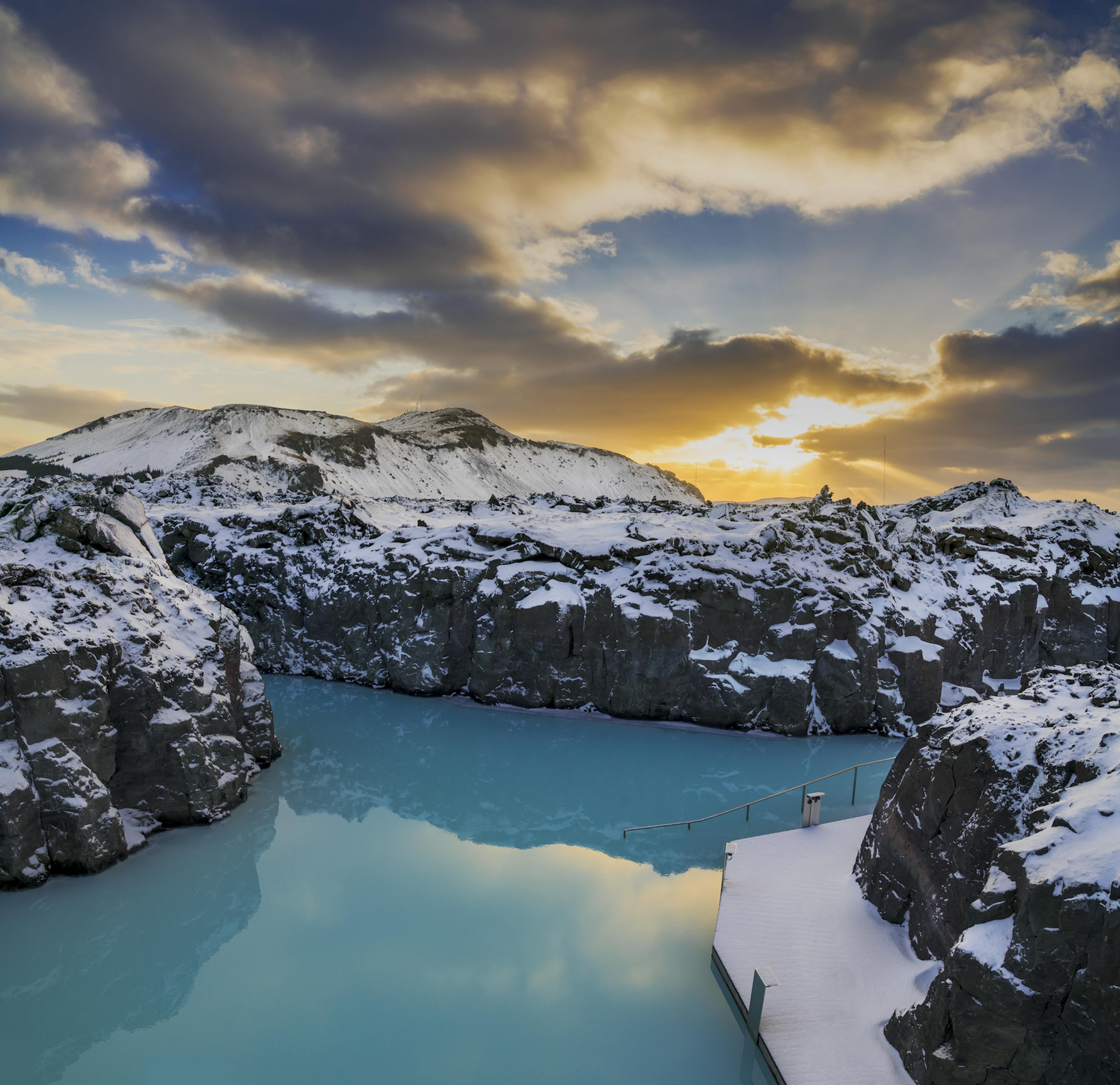 Blue lagoon water with snowy lava surrounding