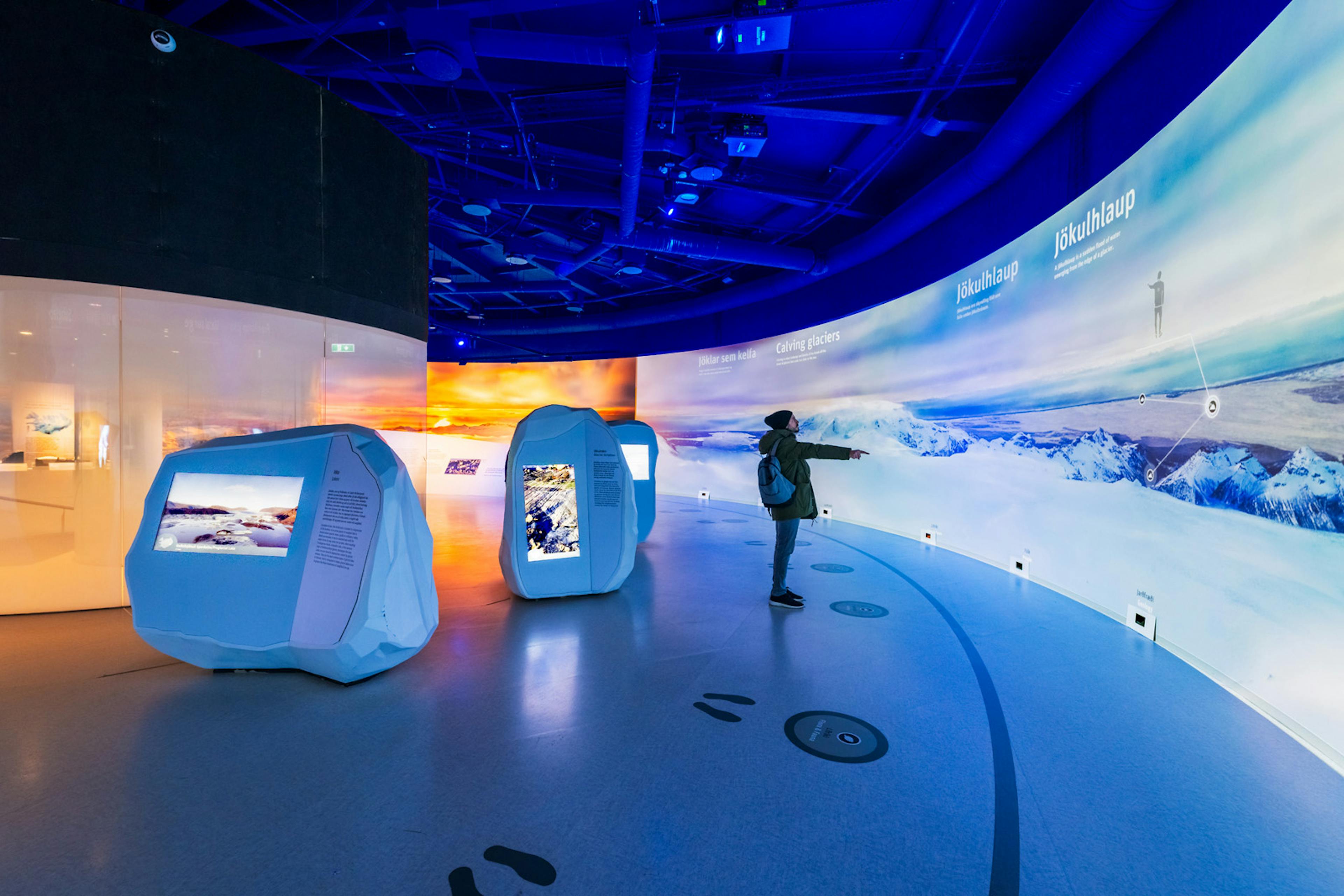 Man interacting with an immersive glacier wall in Perlan museum